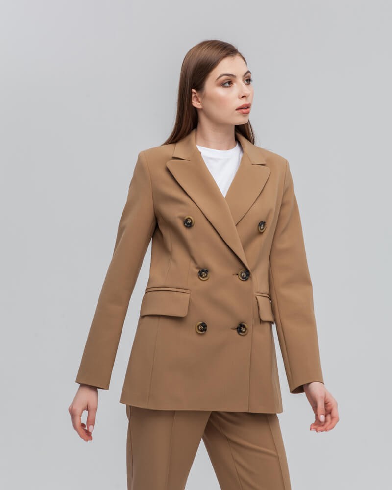 Слегкаприталенный двубортный жакет послужит удачным дополнением не только к деловым нарядам, но и к повседневным образам.Незаменимый элемент базового гардероба, который легко сочетать с брюками, юбками, платьями и денимом.