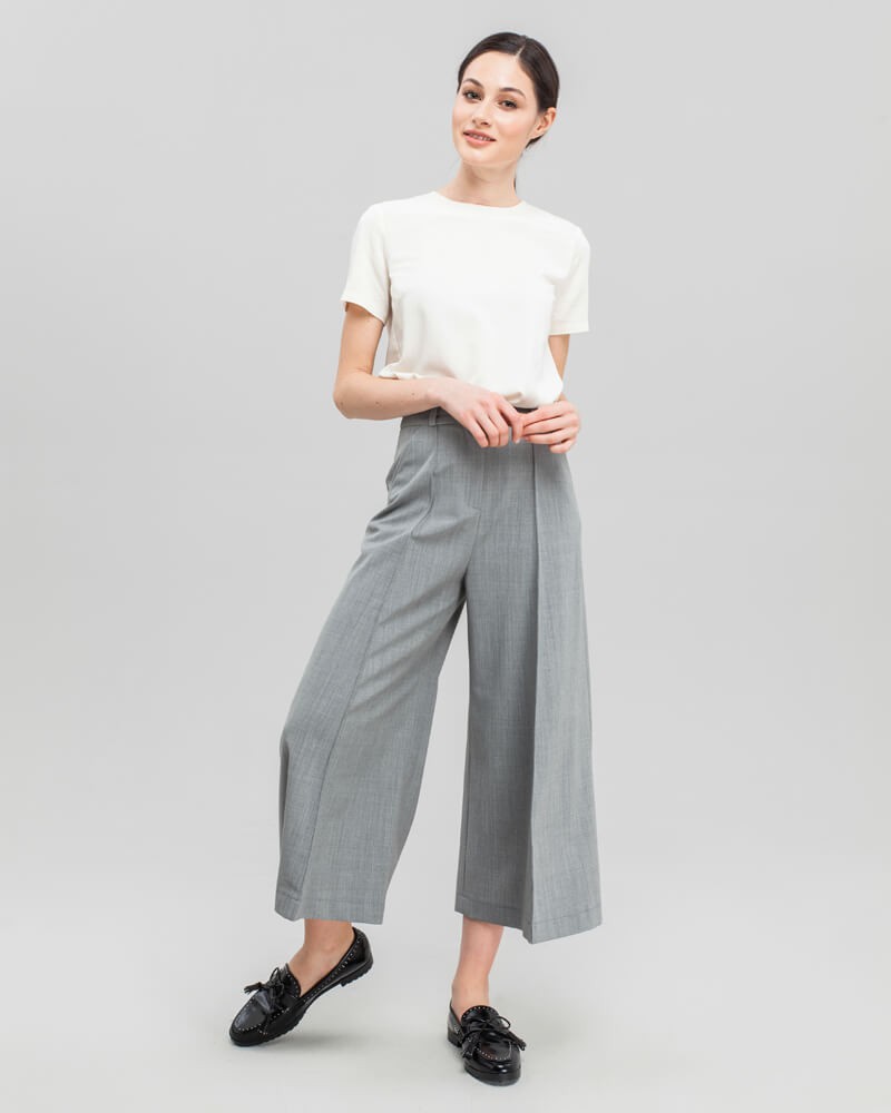 Широкие брюки-кюлоты с простроченной стрелкой и посадкой на талии. Брюки дополнены карманами, застежкой на пуговицу и молнию. За счет силуэта трапеции, который создают кюлоты, можно собирать женственные и утонченные образы.