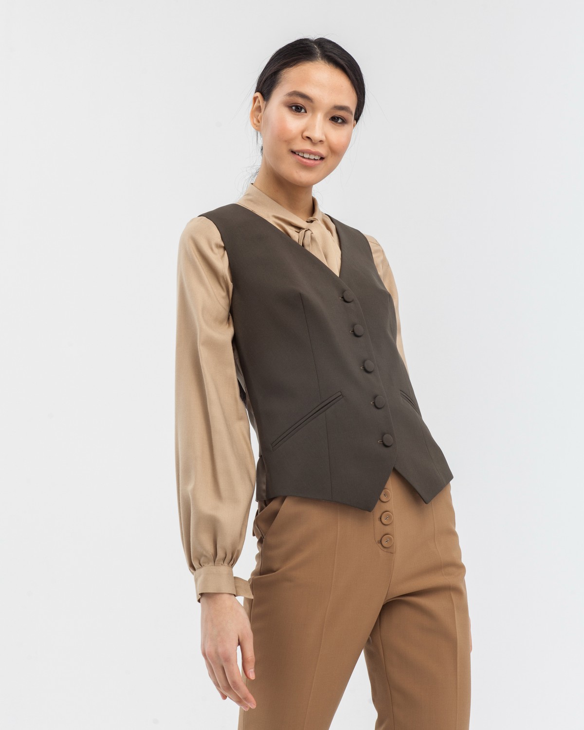 Приталенный жилет с застежкой на пуговицы. Изделие дополнено хлястиком и прорезными карманами. Жилет составит отличный комплект с жакетом и брюками в тон.

На модели размер XS