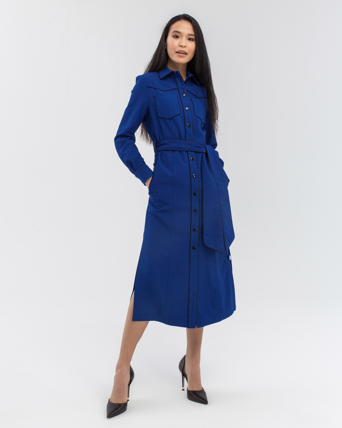 Платье-рубашка приталенного силуэта длины миди с застежкой на пуговицы дополнено поясом в тон из основного материала и кантом черного цвета. С этим платьем можно собрать множество образов, так как оно прекрасно смотрится как самостоятельно, так и в качестве накидки, дополняющей образ с водолазкой и брюками.