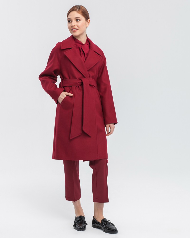 Пальто-халат длины мини с клапанами на карманах, рукавом реглан. Дополнено декоративными отстрочками и воротником-стойка с фигурным вырезом. Данная модель красиво подчеркивает женственные формы за счет пояса.