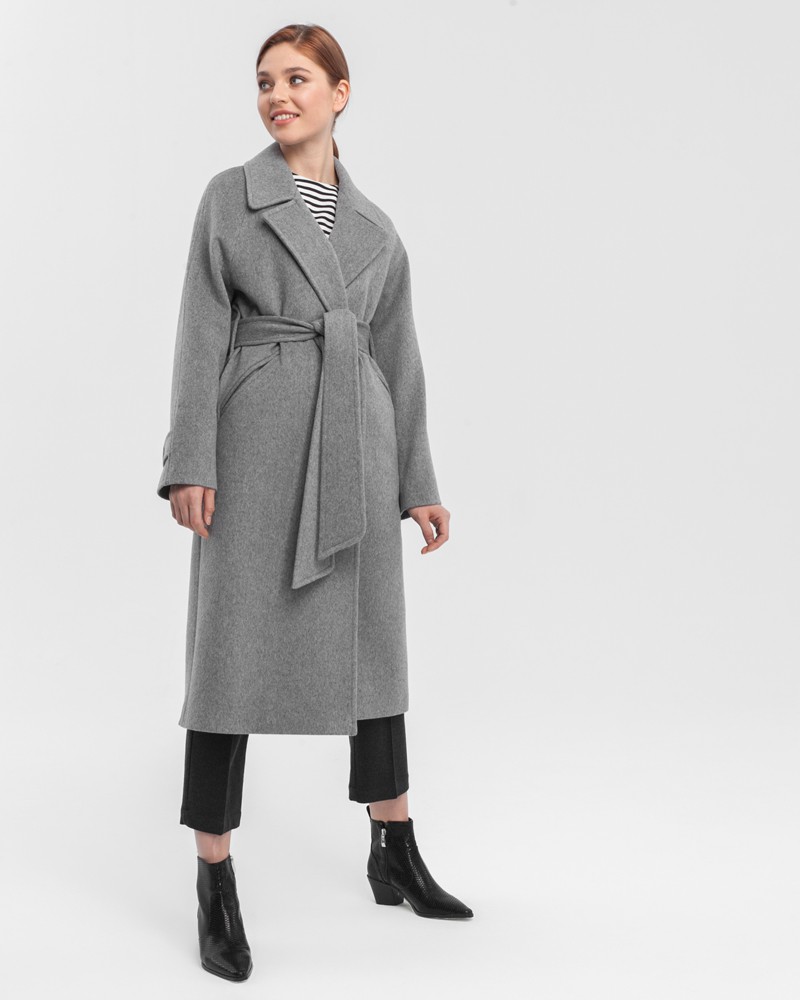 Пальто-халат с клапанами на карманах, рукавом реглан. Дополнено декоративными отстрочками и воротником-стойка с фигурным вырезом. Данная модель красиво подчеркивает женственные формы за счет пояса.

На модели размер XS