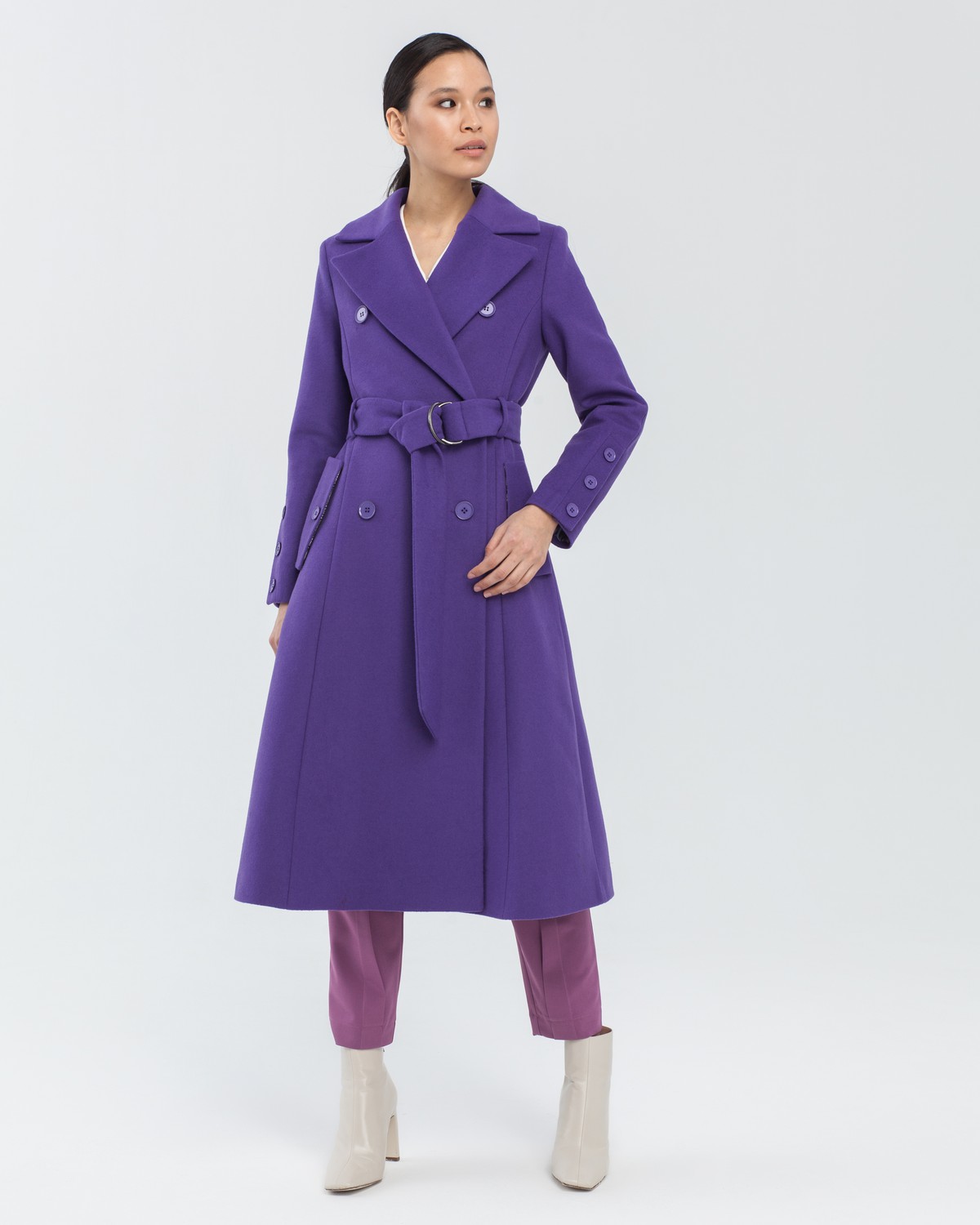 Пальто-тренч с втачанным рукавом классической посадки. Дополнено поясом из основного материала с металлической пряжкой и пуговицами в тон. За счет рельефов и формы трапеция, расширяющейся к низу, пальто создает женственный и утонченный силуэт.

На модели размер XS

