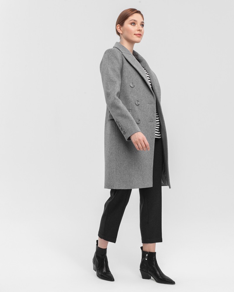 Двубортное укороченное пальто из плотной шерсти с кашемиром. Модель имеет английский воротник, дополнена карманами с клапанами. Отличительная особенность данной модели - шлица по рукаву на 4 пуговицы. Пуговицы выкрашены вручную.

На модели размер XS