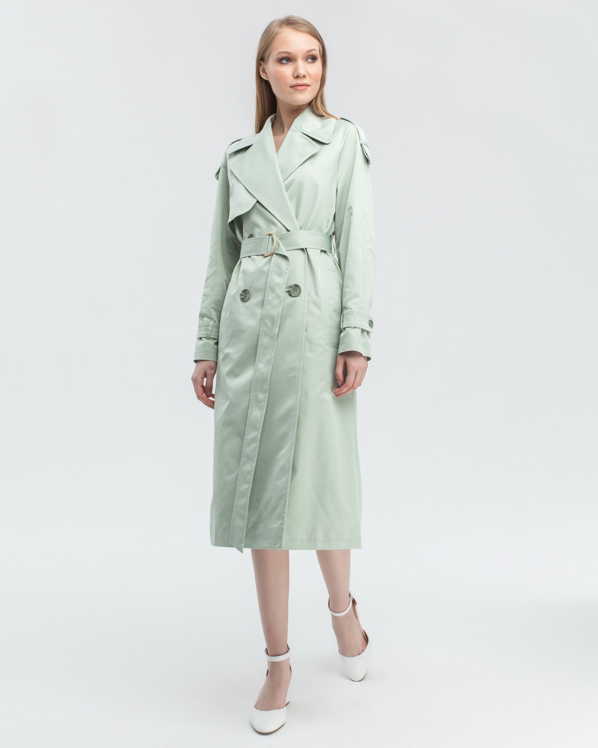 Тренч классической посадки с рукавом реглан. Дополнен погонами, патами на рукавах и поясом в тон изделия с металлической пряжкой. Выполнен из плащевой ткани с добавалением хлопка, на подкладке. Защитит от ветра весенними вечерами.