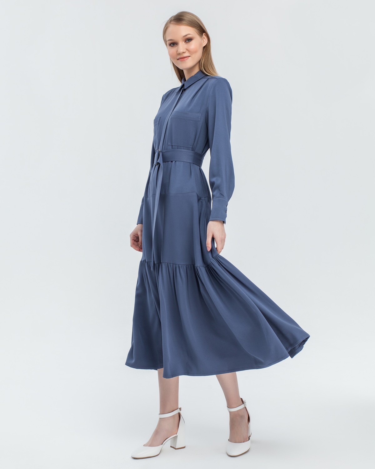 Платье-рубашка длины миди с воланом на подоле. Дополнена поясом в тон с металлической пряжкой и накладными карманами на груди, отсылающимик стилюсафари.