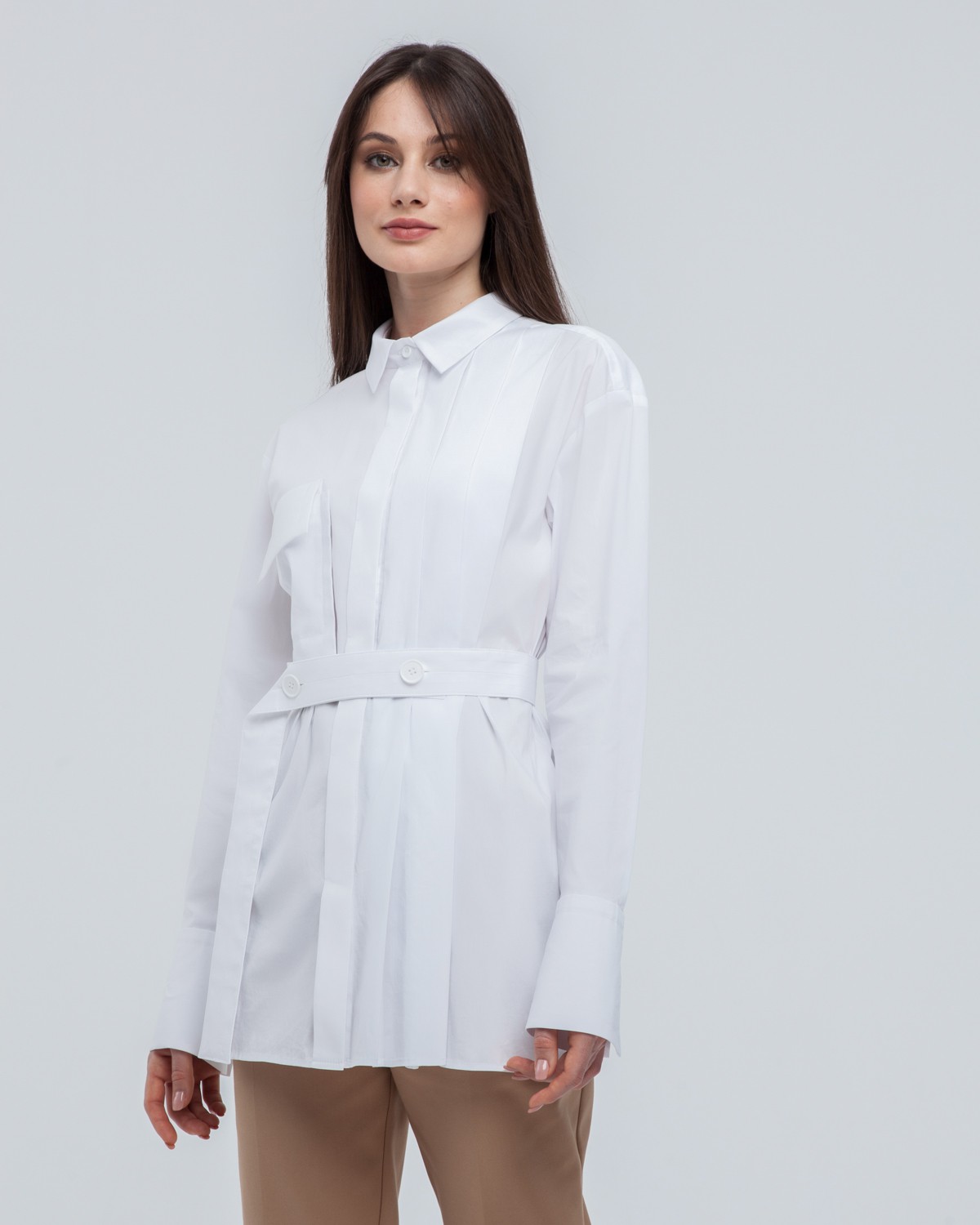 Акцентная удлиненная рубашка с объемным накладным карманом и плиссировкой по левому боку. Дополнена поясом на пуговицах в тон изделия. Модель позволяет носить ее как с поясом, так и без. Идеальный вариант для создания уникального делового или повседневного образа.

На модели размер XS