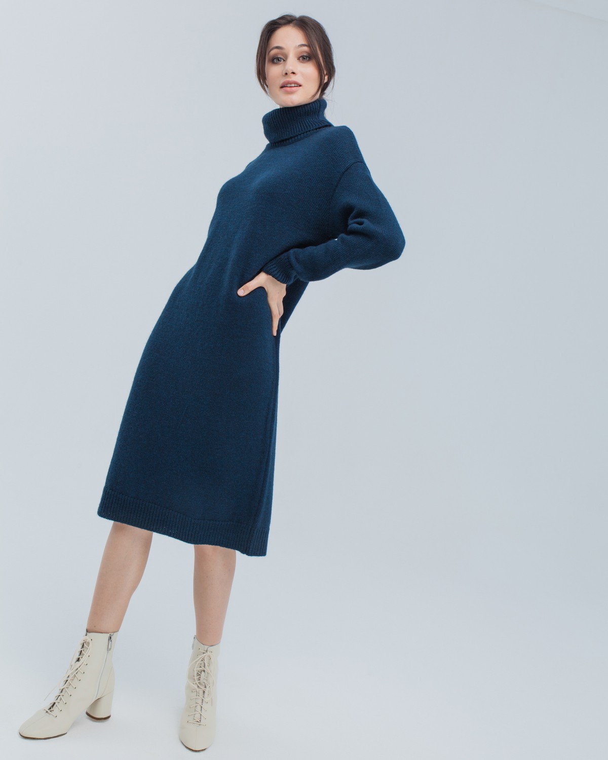 Трикотажное платье длины миди прямого кроя. Дополнено широким высоким воротом. По низу рукава и низу изделия притачан манжет, что создает удобство при ношении платья. Идеальный вариант для прохладных зимнихпрогулок и уютных посиделок с друзьями.