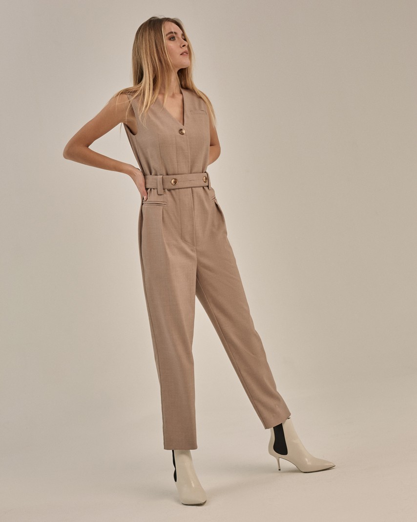 Комбинезон прямого силуэта с V-образным вырезом и укороченными штанинами. Модель дополнена пуговицей на передней части из полиэфира. Комбинезон со съемным поямом с 2 акцентными роговыми пуговицами. Можно сочетать как с лодочками для элегантного образа, так и с кроссовками для расслабленного лука.

На модели размер XS