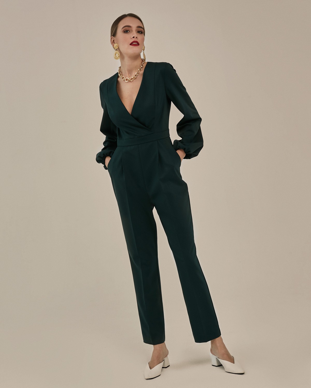 Комбинезон с широкими рукавами и запахом на полочке. Модель дополненапоясом на линии талии.Снизу - брюки-бананы, зауженные к низу. На спинке: потайная молния. Удобный вариант для вечеринки - можно комфортно танцевать, сочтая комбинезон как с лодочками, так и обувью на плоском ходу.

На модели размер XS