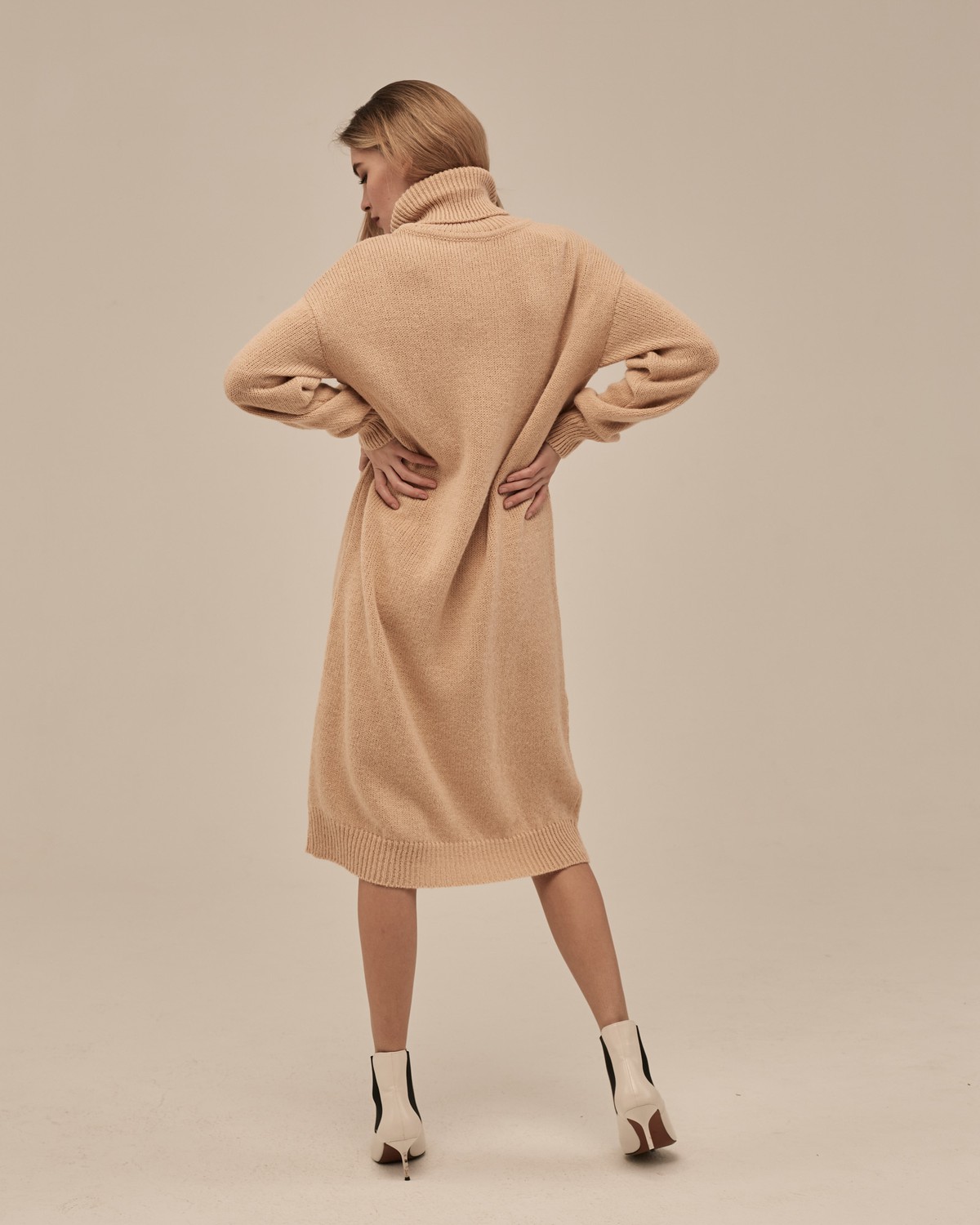 Трикотажное платье длины миди прямого кроя. Дополнено широким высоким воротом. По низу рукава и низу изделия притачан манжет, что создает удобство при ношении платья. Идеальный вариант для прохладных зимнихпрогулок и уютных посиделок с друзьями.