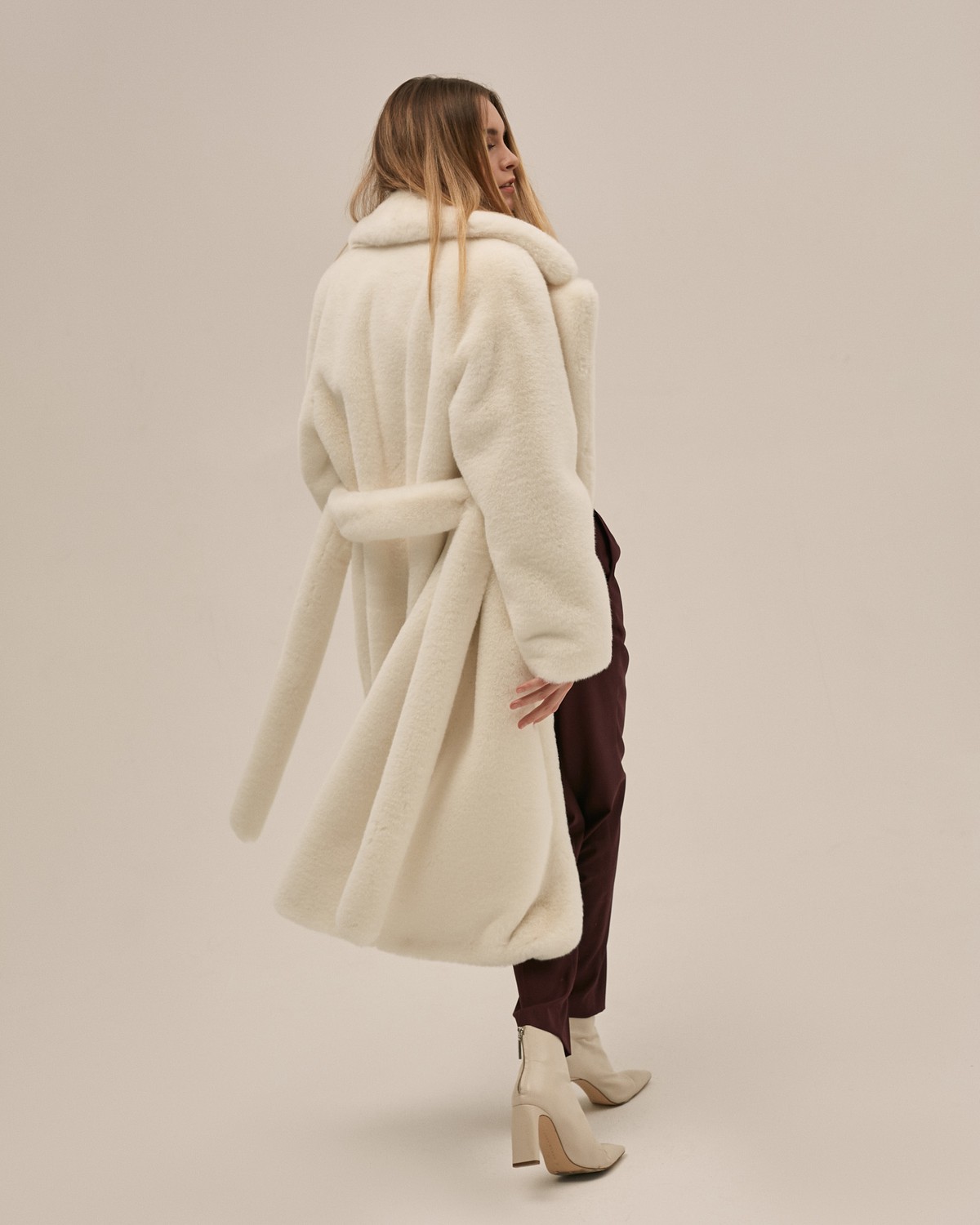 Шуба из искусственного меха прямого кроя длины миди с рукавом реглан и английским воротником. Модель дополнена поясом из основного материала и застегивается на крючки.

Температурный режим: до -10 градусов

На модели размер XS