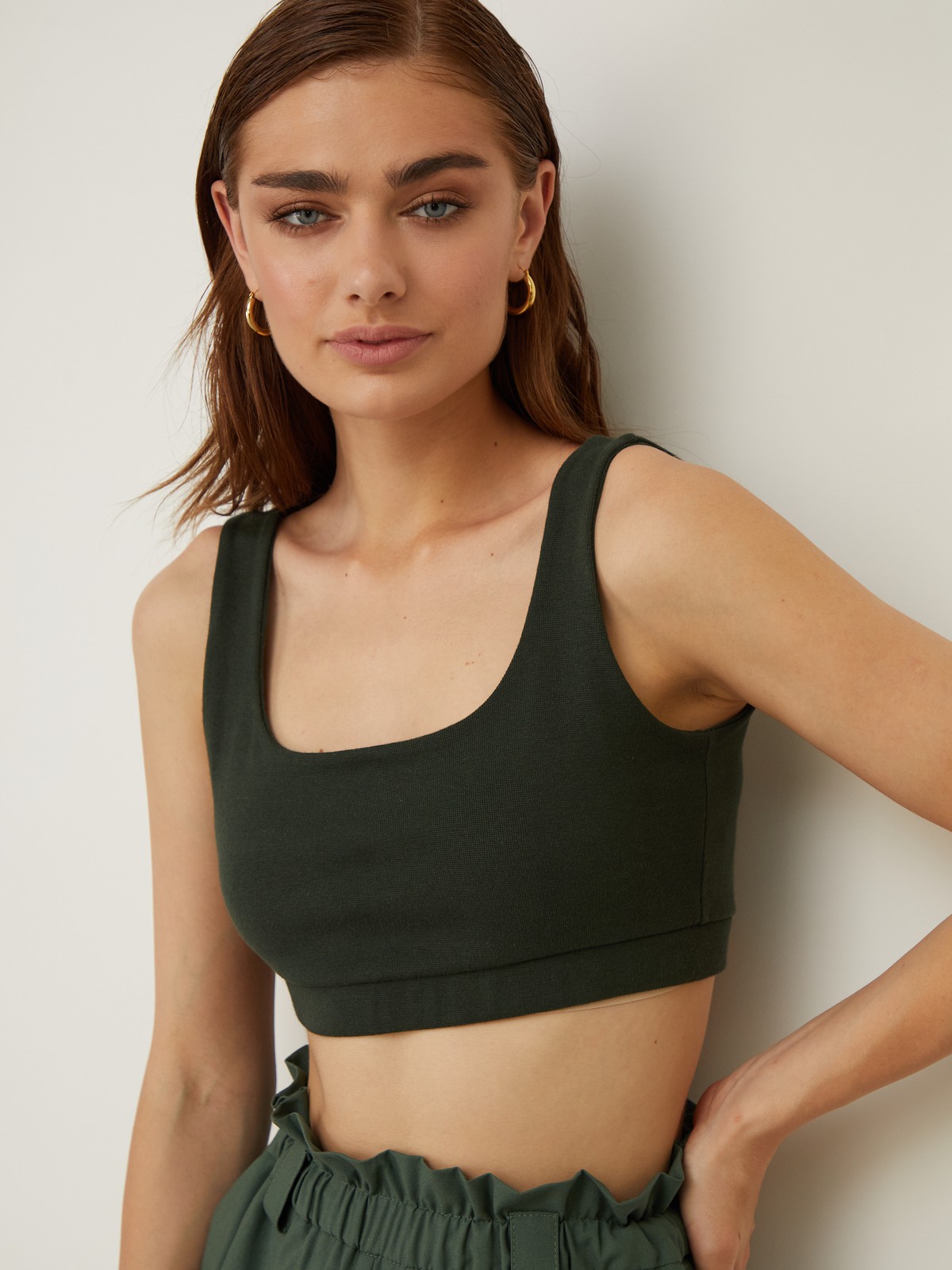 Укороченный топ облегающего кроя выполнен из двухслойной мягкой хлопковой ткани. Ткань топа плотная, что позволит носить его без нижнего белья. Квадратный вырез и широкие бретели подчеркивают плечи и линию декольте.

На модели размер XS