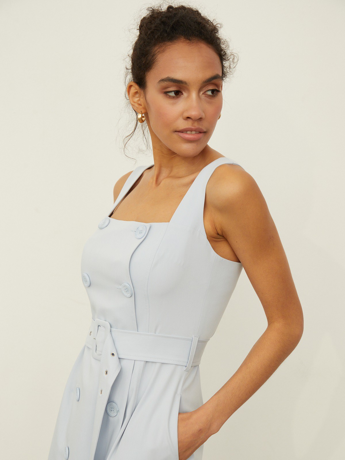 Платье-сарафан оформлено юбкой А-силуэта и топом с двубортной застежкой на пуговицы в тон. Квадратный вырез лифа и широкие бретели подчеркивают ретро-настроение. Акцентируйте талию широким поясом из комплекта и дополните образ сумкой-ведерком и аккуратными босоножками.

На модели размер XS