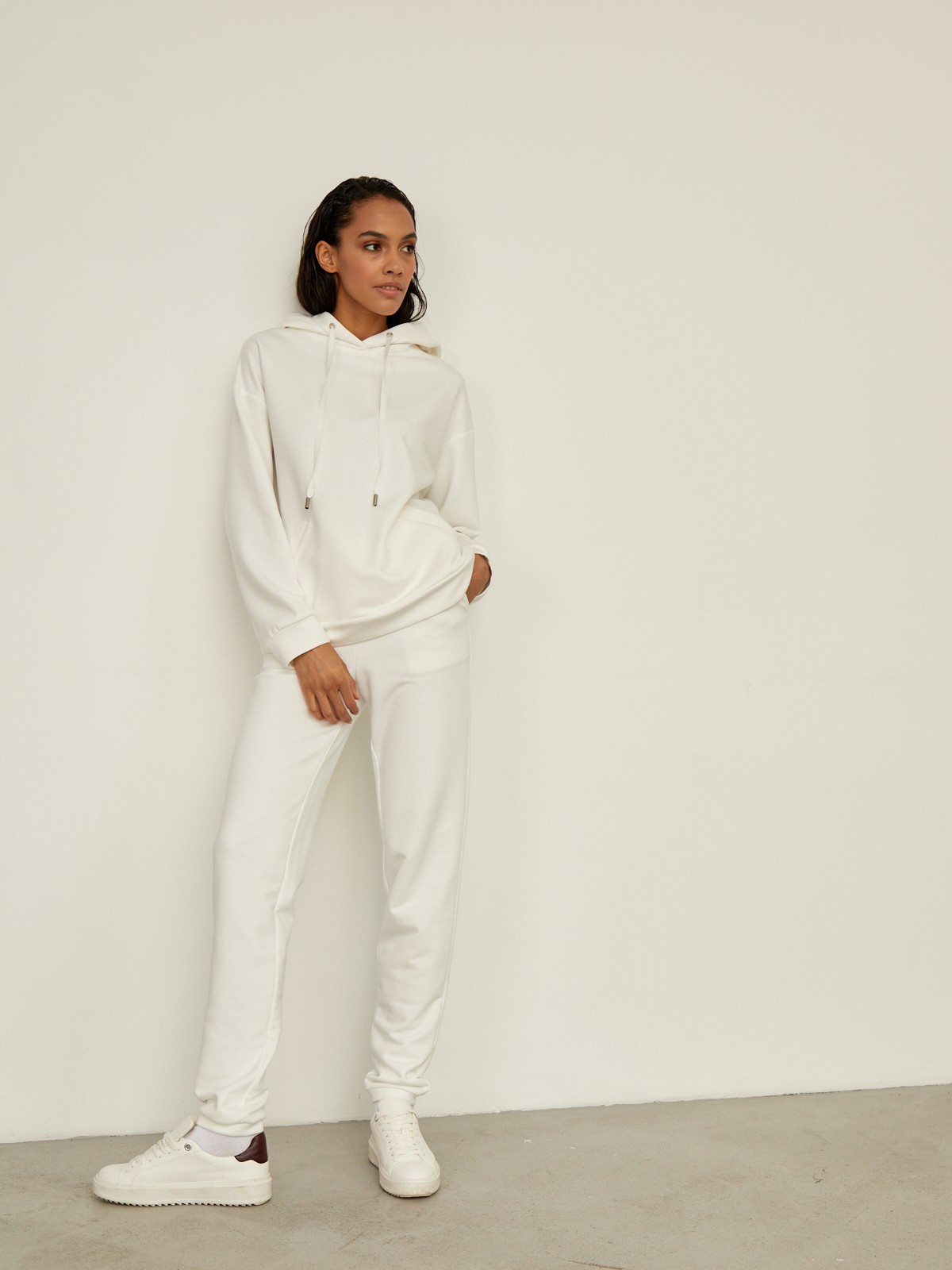 Брюки свободного спортивного силуэта. Модель дополнена манжетами из основной ткани по низу изделия и карманами по боковым швам. На поясе у брюк пояс, регулируемый завязками. Дополните свой образ толстовкой в тон изделия.

На модели размер XS