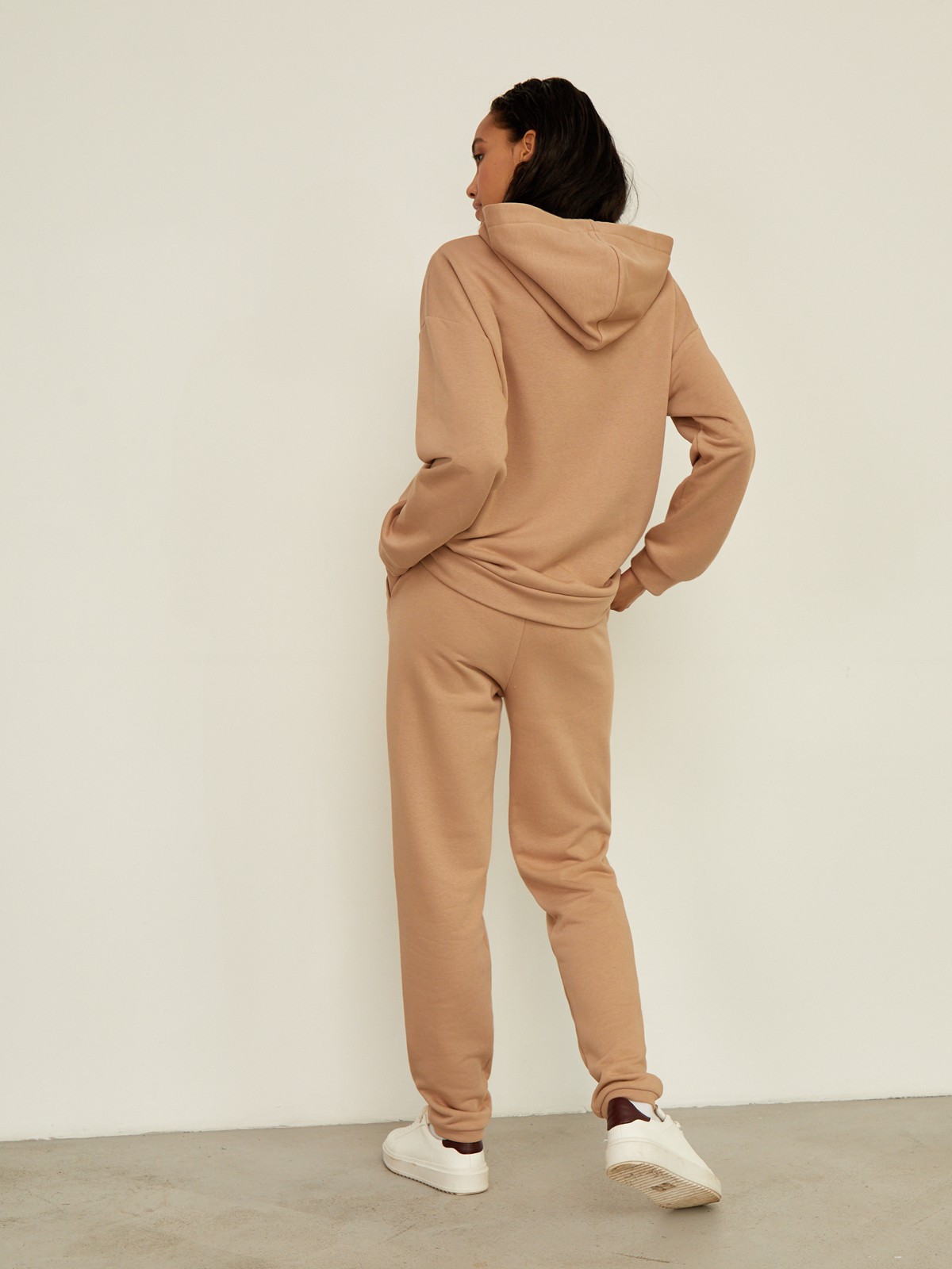 Брюки свободного спортивного силуэта. Модель дополнена манжетами из основной ткани по низу изделия и карманами по боковым швам. На поясе у брюк пояс, регулируемый завязками. Дополните свой образ толстовкой в тон изделия.

На модели размер XS