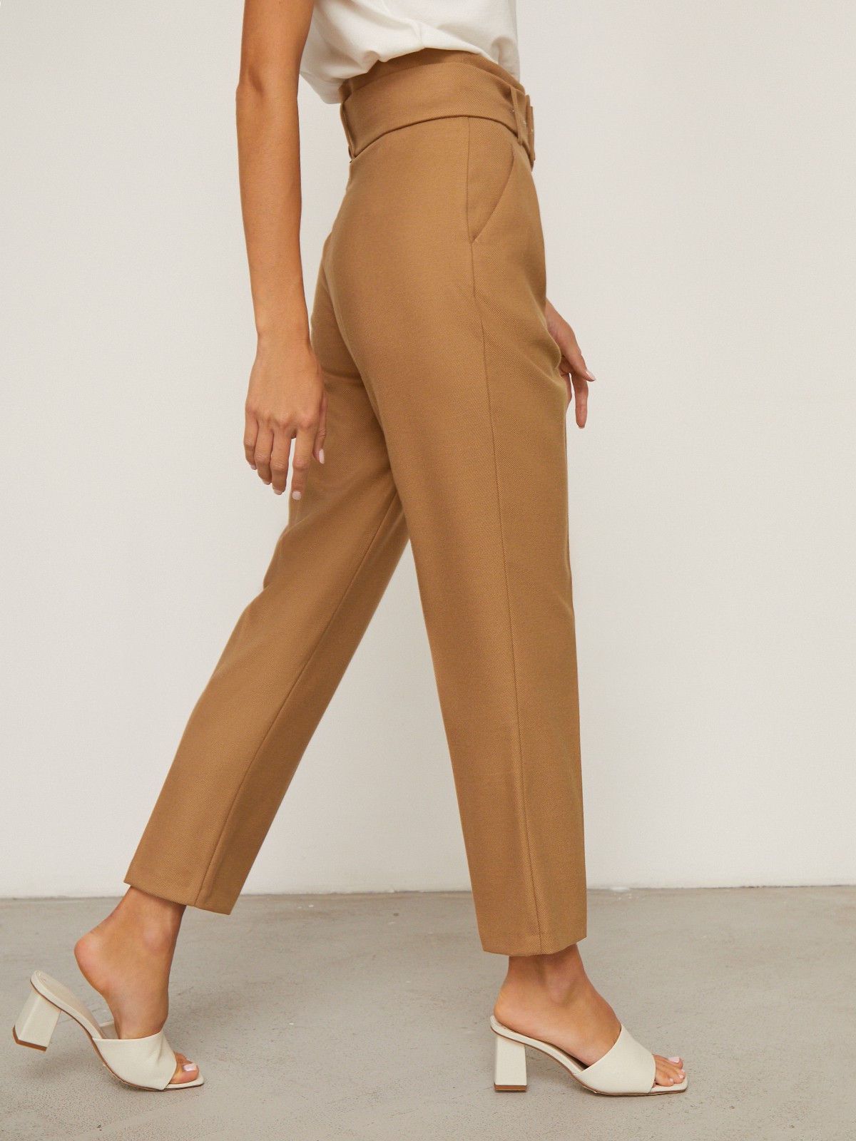 Брюки зауженные с завышенной посадкой, цвет: кэмел Allweneed Слегка зауженные брюки на высокой талии. Дополнены поясом с трендовой в этом сезоне роговой пряжкой. Сочетайте с однотонным жакетом из комплекта для создания изысканного, делового или вечернего образа. Брюки этой модели выпускаются в нашей коллекции уже несколько сезонов подряд, поэтому их посадка безупречна.
На модели размер XS