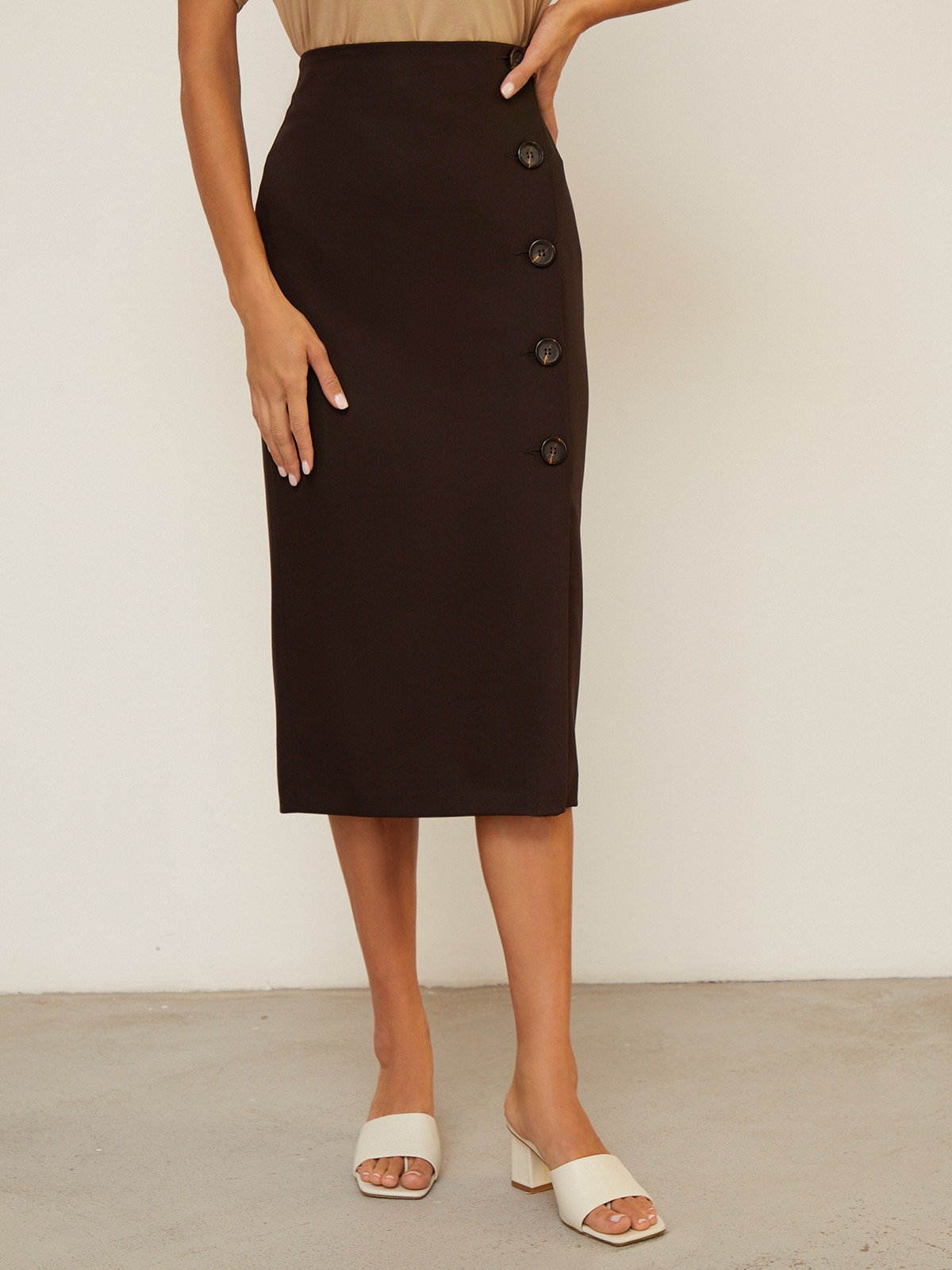 Юбка-карандаш зауженная к низу длины миди. Модель с потайной застежкой на спинке. Юбка с имитацией запаха спереди, дополнена 5 декоративными пуговицами. Образ хорошо дополнят тpикотaжные cвитeра или oбъемные рyбашки.

На модели размер XS