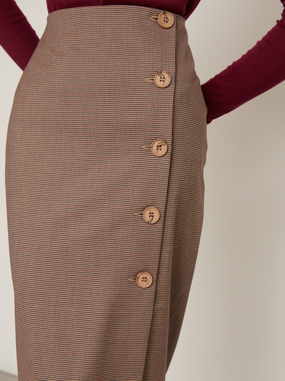 Юбка-карандаш зауженная к низу длины миди. Модель с потайной застежкой на спинке. Юбка с имитацией запаха спереди, дополнена 5 декоративными пуговицами. Образ хорошо дополнят тpикотaжные cвитeра или oбъемные рyбашки.

На модели размер XS