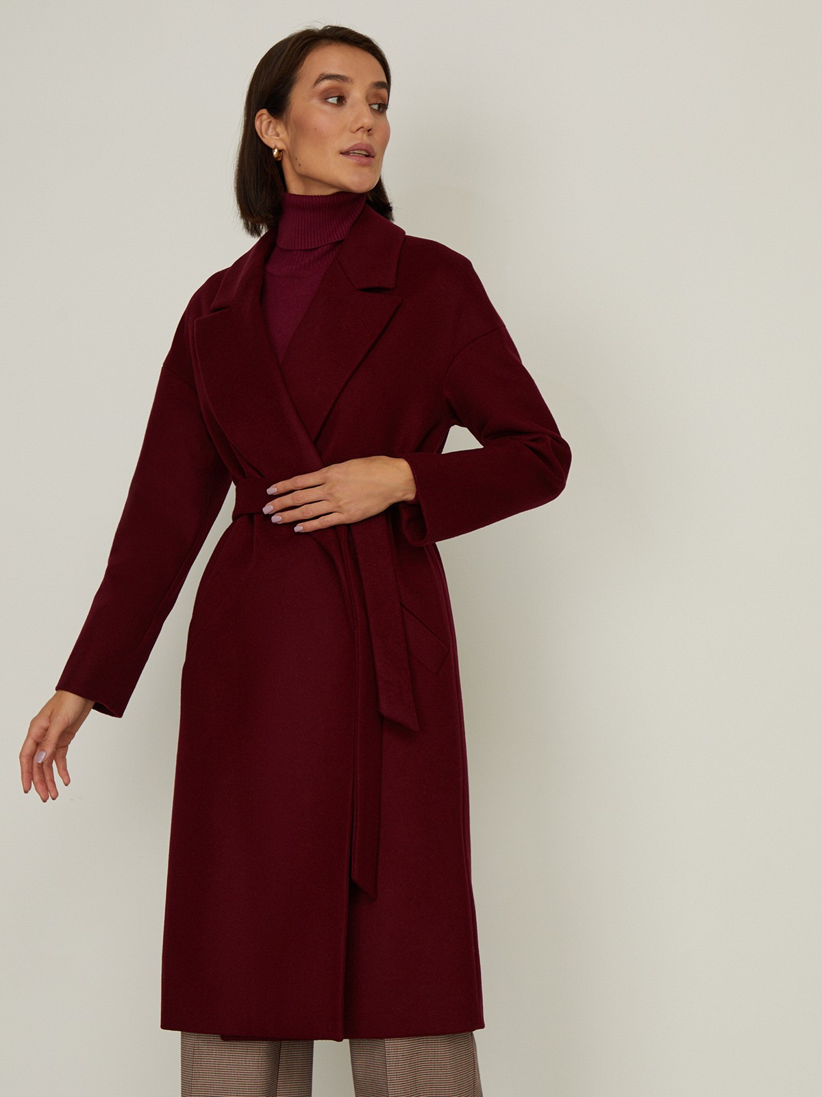 Пальто-халат из плотной шерсти. Модель прямого силуэтас английским воротником.Пальто дополнено двумя вместительными карманами,без застежки, с поясом из основного материала.

На модели размер XS