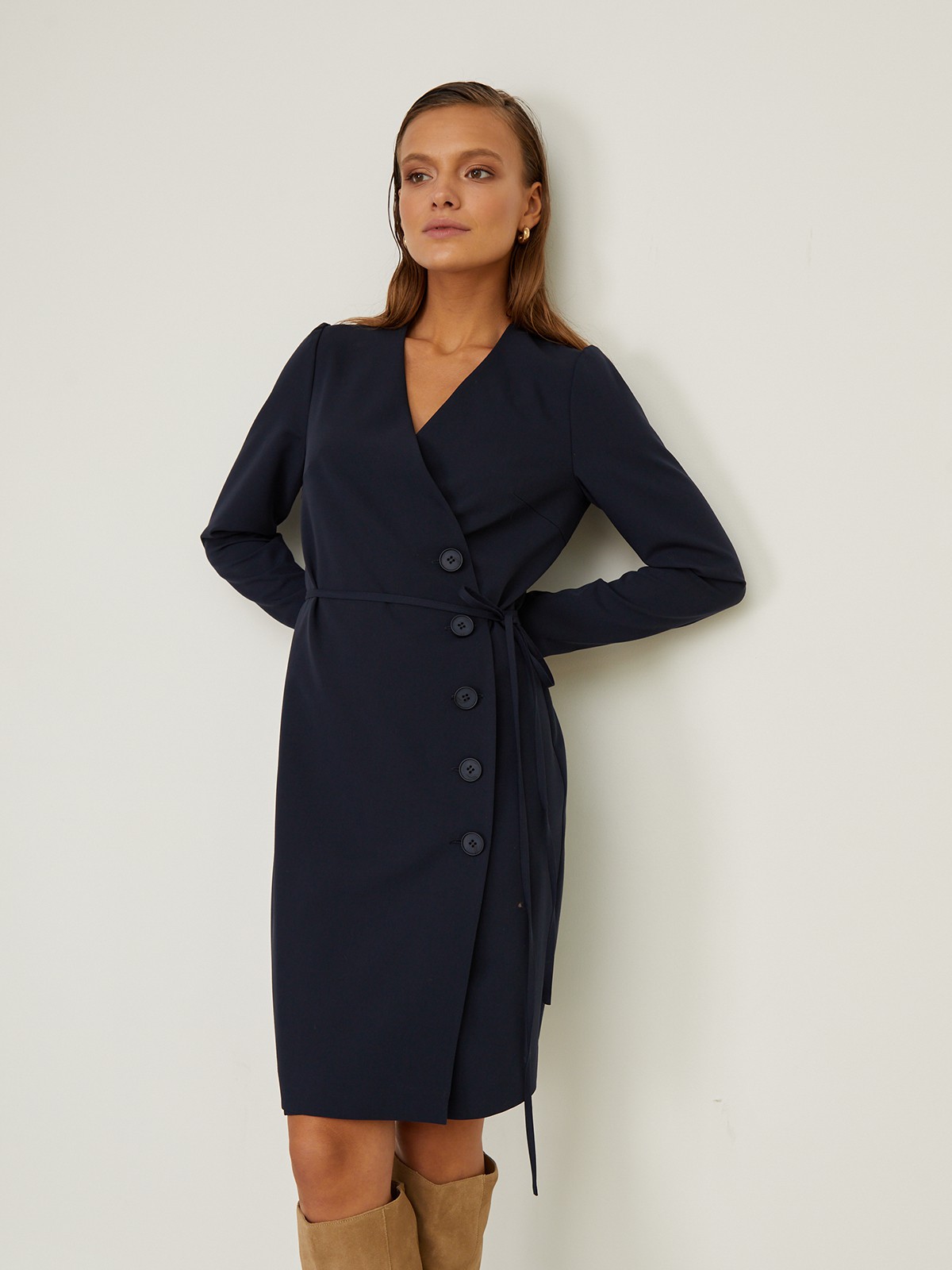 


Платье с драпировкой на запах и V-образным вырезом выполнено из однотонной ткани. Планка-застежка на крупные однотонные пуговицы сбоку. Тонкий пояс на талии.

На модели размер XS