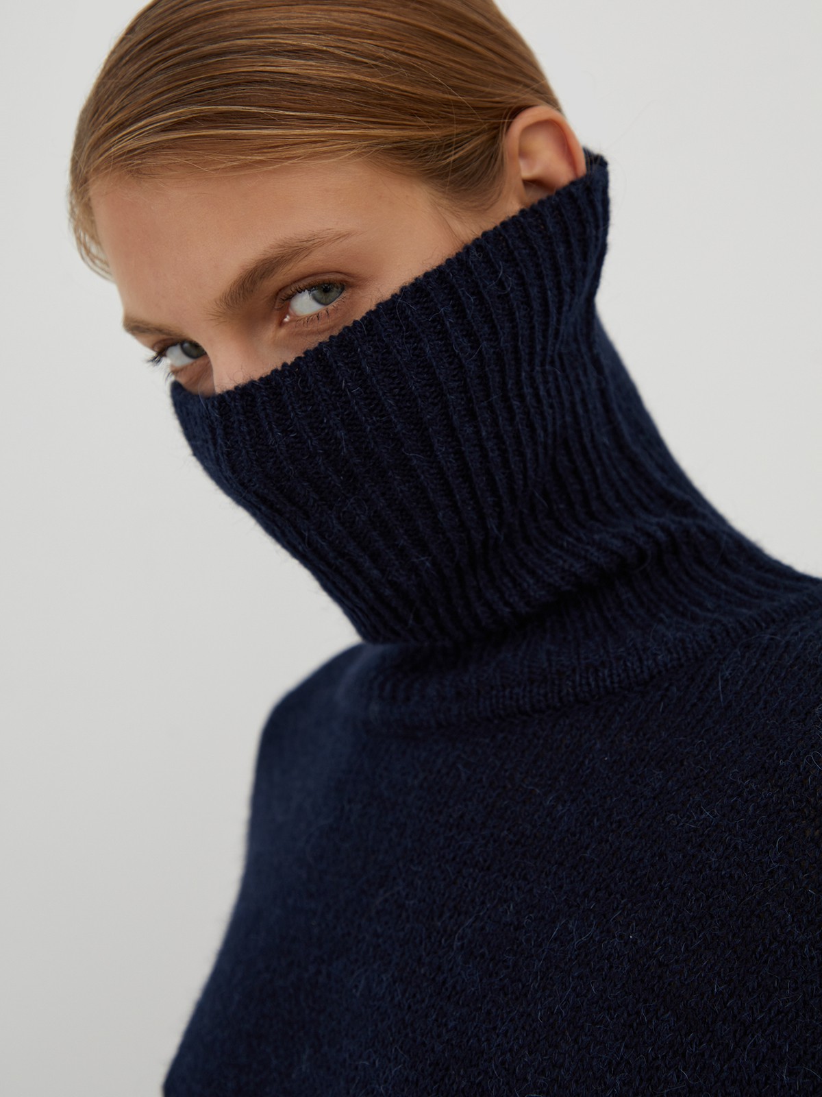 Трикотажное платье длины миди прямого кроя. Дополнено широким высоким воротом. По низу рукава и низу изделия притачан манжет, что создает удобство при ношении платья. Идеальный вариант для прохладных зимнихпрогулок и уютных посиделок с друзьями.