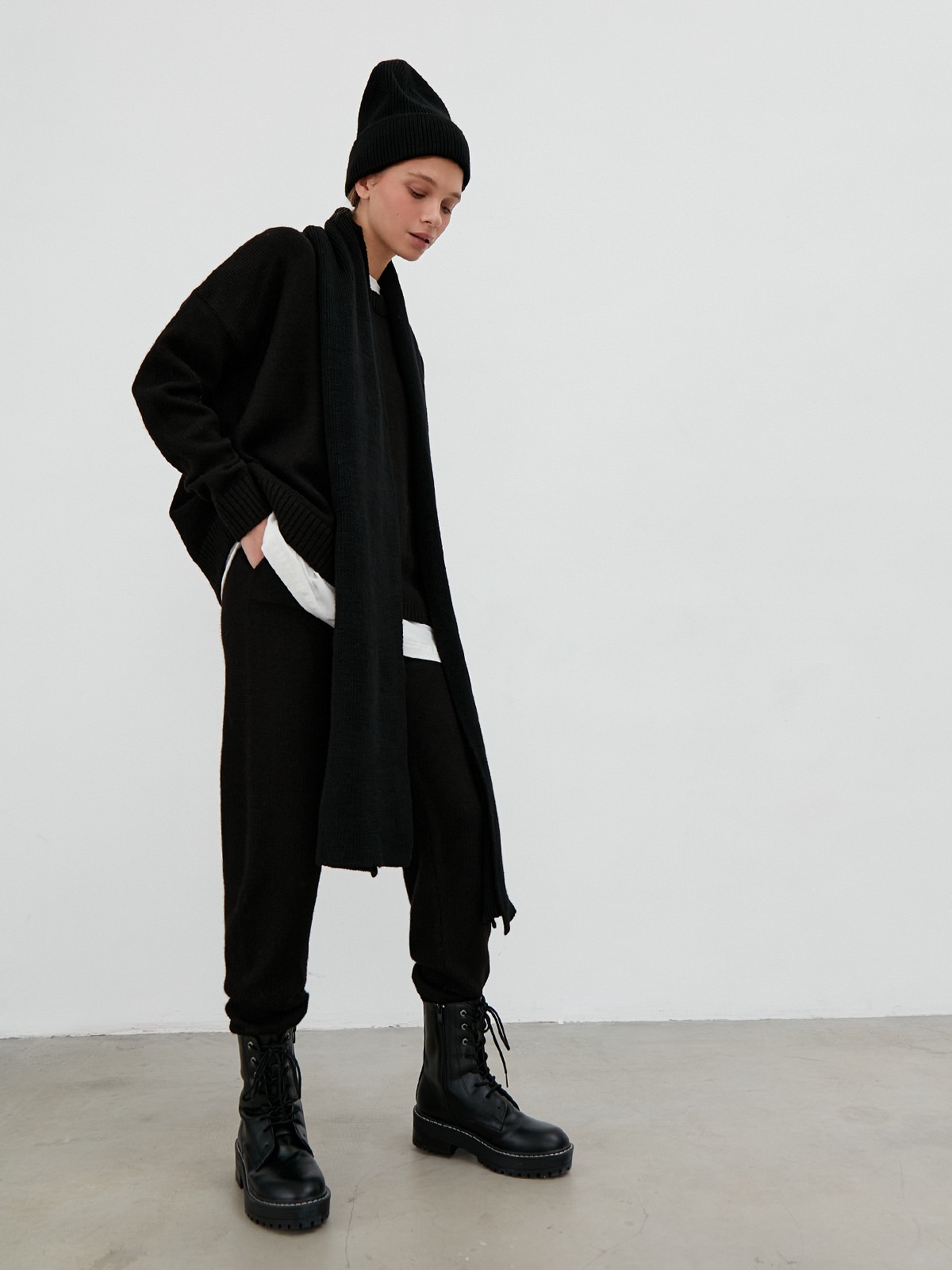 Костюм из вязанного трикотажа, состоящий из кофты и брюк. Кофта свободного силуэта со спущенным плечом. Брюки прямые с резинкой на поясе, зауженные к низу.

На модели размер one size