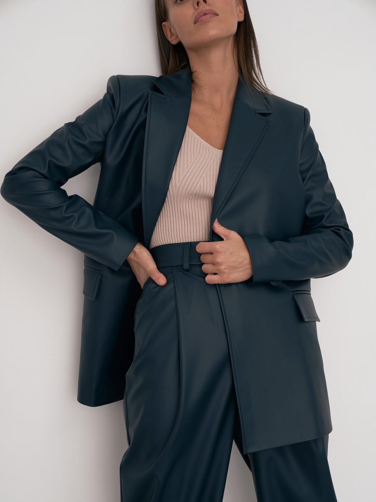 Жакет двубортного кроя выполнен из эко-кожи и оформлен заостренными лацканами, акцентированной плечевой линией и карманными клапанами по бокам.

На модели размер XS