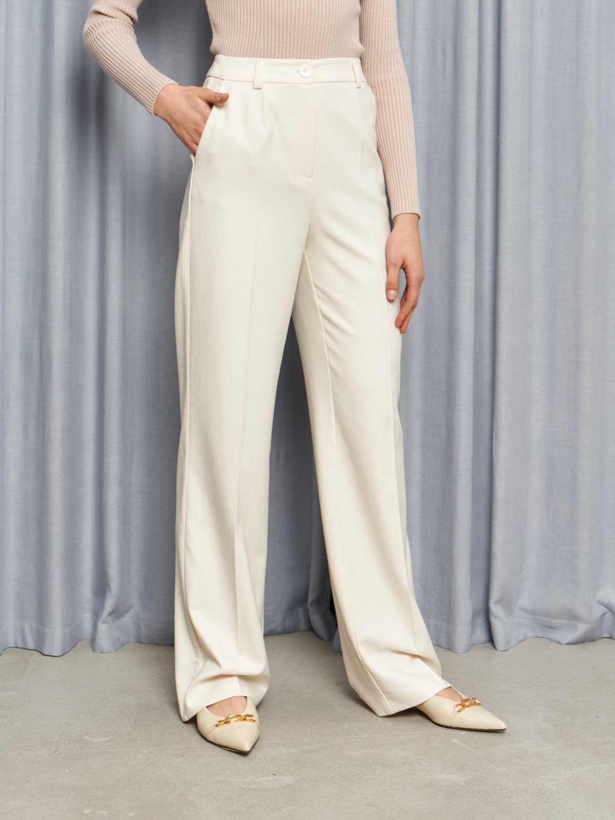 Костюмные брюки прямого кроя оформлены кантиком и продольными стрелками, вытягивающими силуэт. Пришивной пояс со шлевками на талии.

На модели размер XS