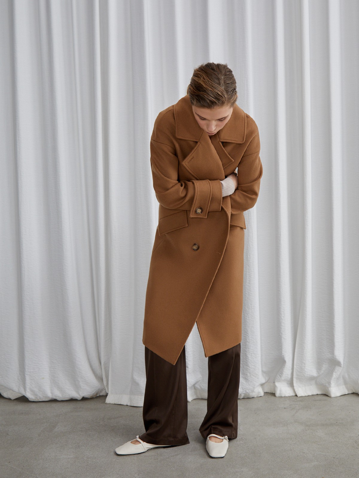 Пальто-кокон двубортного кроя с покатым рукавом и декоративными деталями: карманными клапанами, хлястиками на манжетах и лацканами у воротника.

На модели размер XS