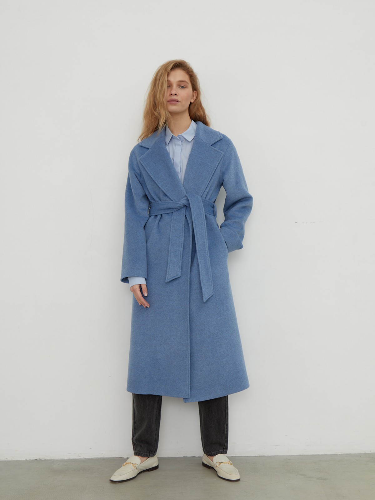 Утонченное пальто-халат А-силуэта. Модель дополнена широким поясом в тон основной ткани.

На модели размер XS