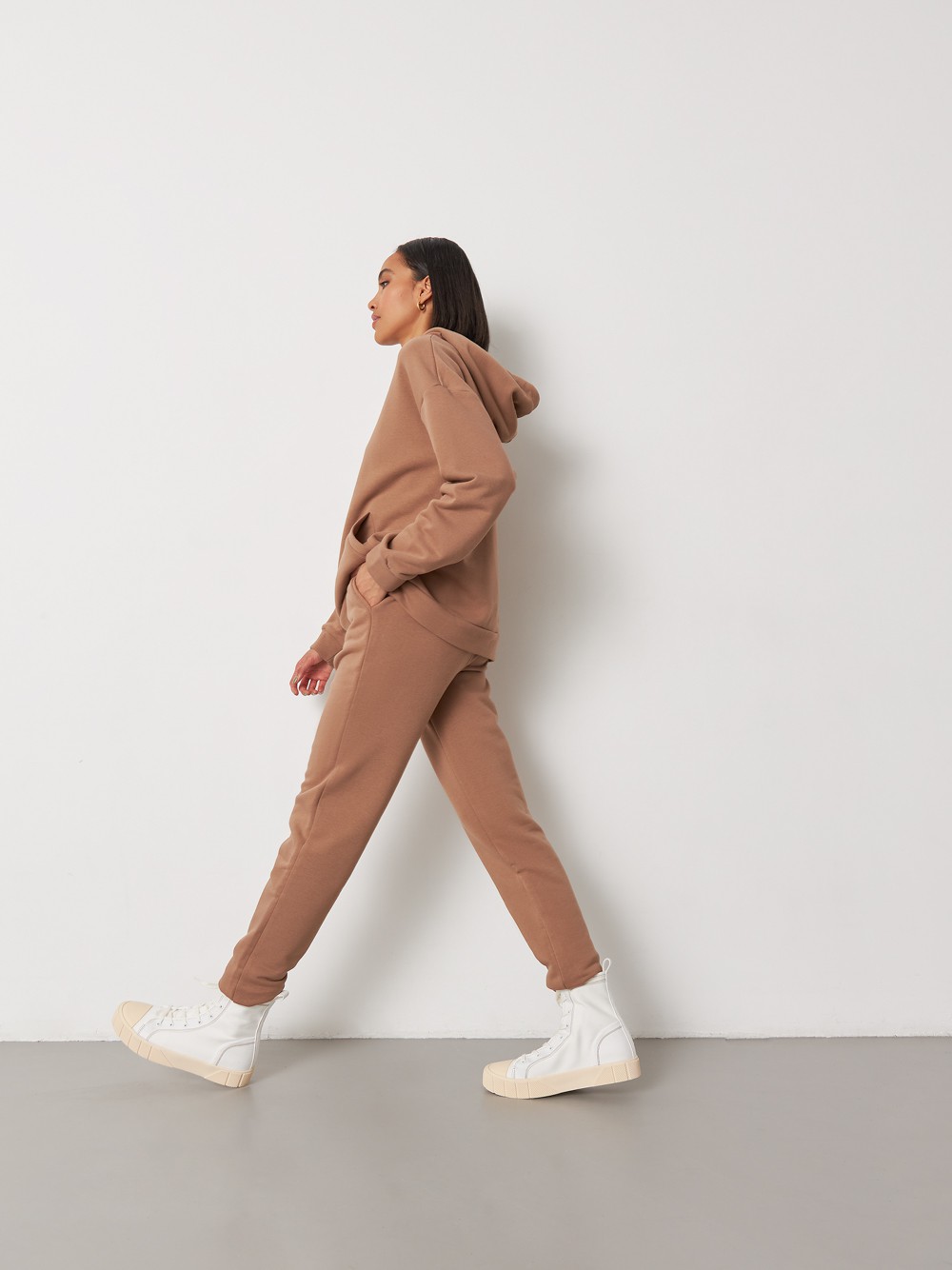 Брюки свободного спортивного силуэта. Модель дополнена манжетами из основной ткани по низу изделия и карманами по боковым швам. На поясе у брюк пояс, регулируемый завязками. Дополните свой образ толстовкой в тон изделия.

На модели размер XS