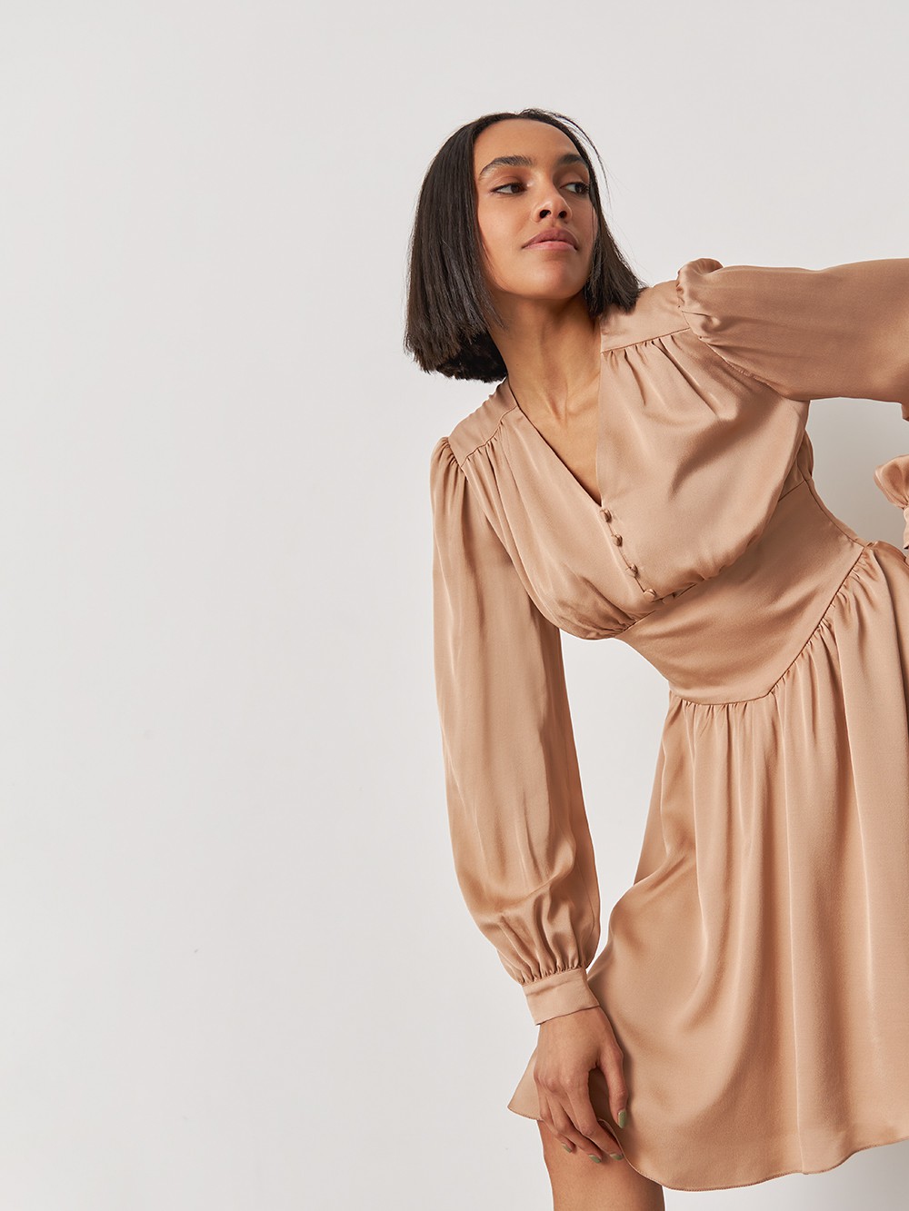 


Мини платье из струящейся ткани с декоративными сборками по всей длине: по линии декольте, объемным рукавам, манжетам и юбке. Застежка на обтяжные пуговицы усиливает романтичное настроение образа.

На модели размер XS