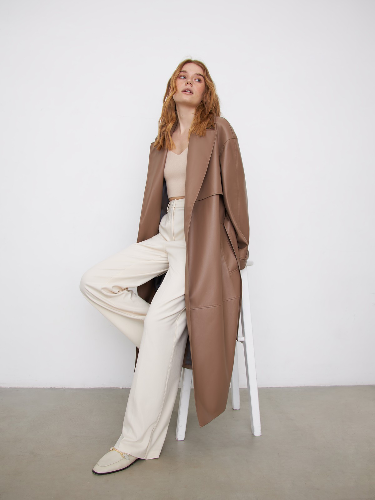 Двубортный плащиз эко-кожи - новая классика современного гардероба. Модель свободной посадки акцентирована отлетными деталями, поясом на талии и скошенными прорезными карманами с широкими листочками.

На модели размер XS/S