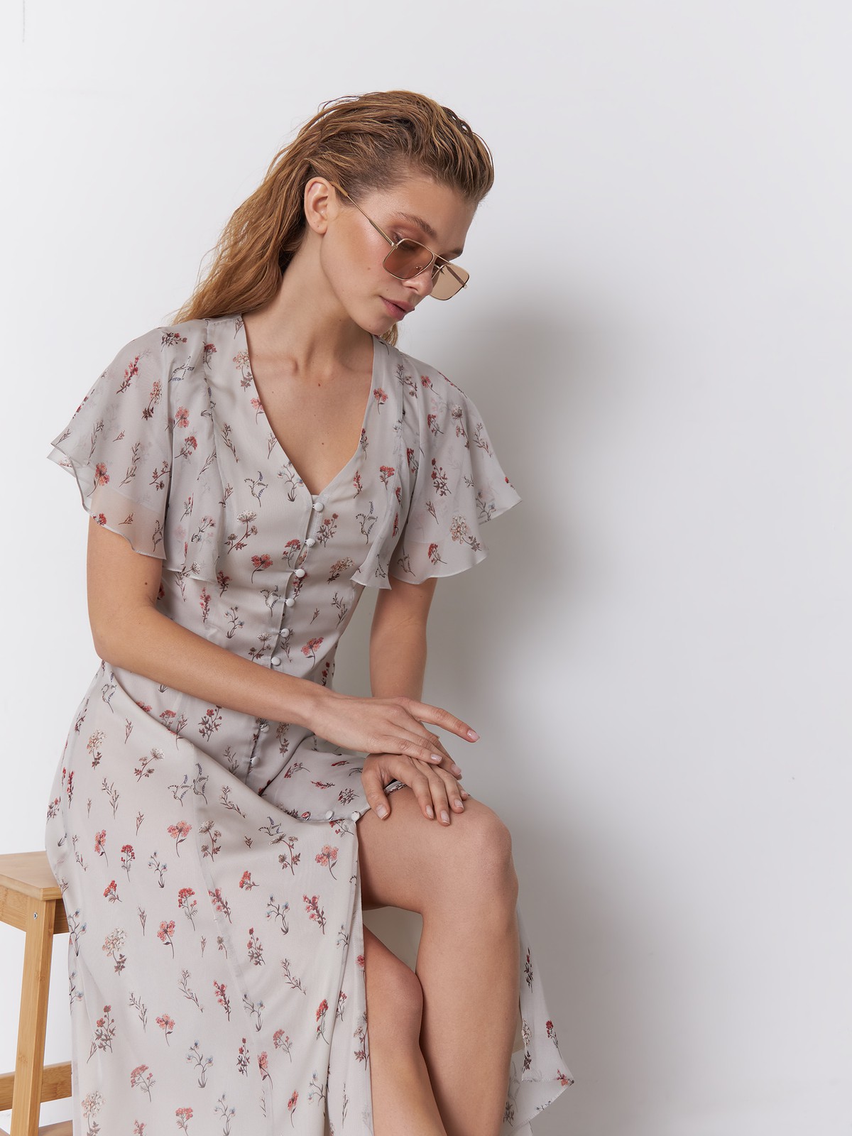 Платье миди из струящегося полупрозрачного шифона с принтом. Многослойные рукава-крылышки вторят сборкам на подоле платья и придают романтичное настроение. Аккуратный V-образный вырез переходит в застежку на обтяжные пуговицы. Идеальный летний силуэт.

На модели размер S