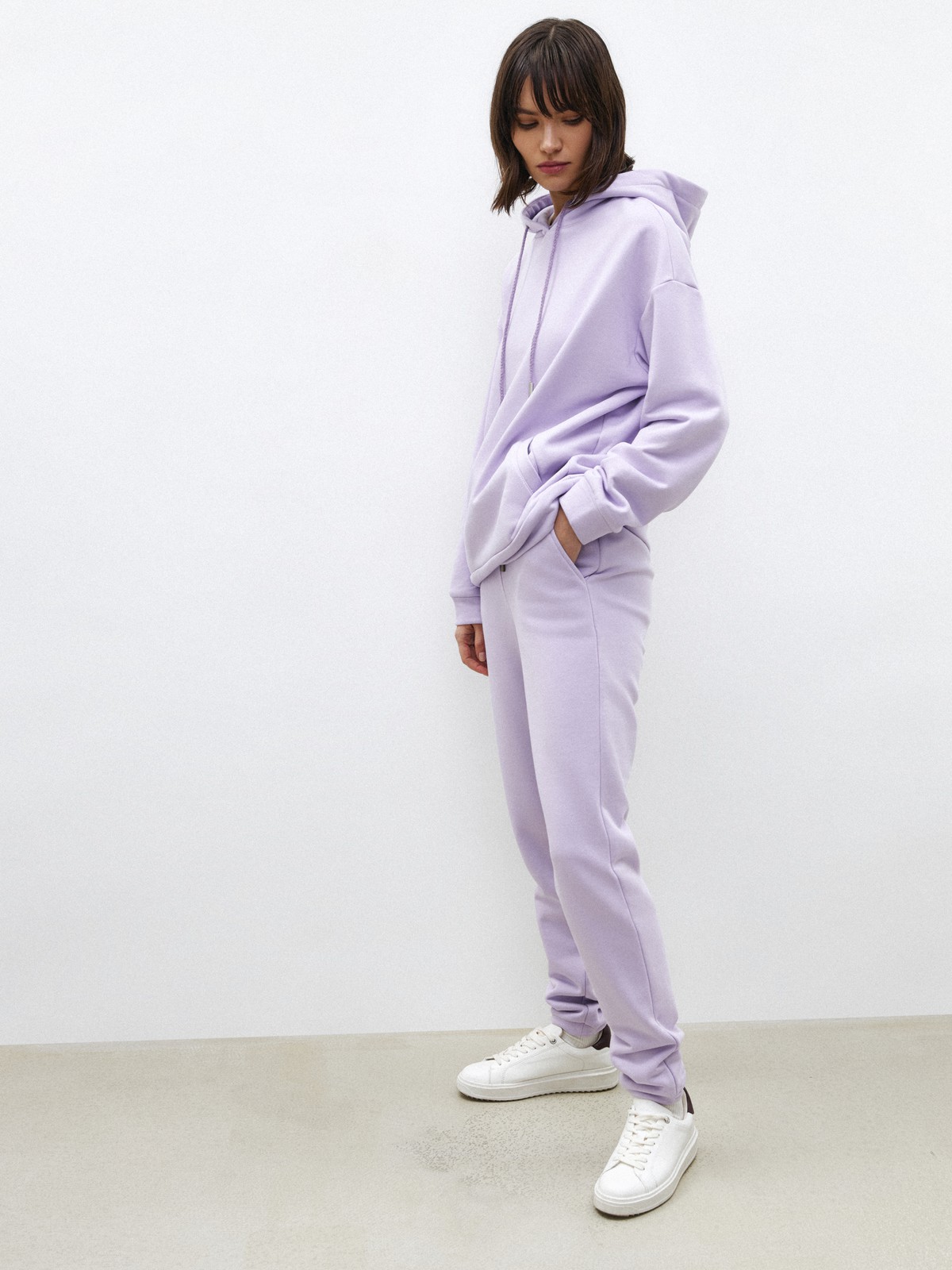 Брюки свободного спортивного силуэта. Модель дополнена манжетами из основной ткани по низу изделия и карманами по боковым швам. На поясе у брюк пояс, регулируемый завязками. Дополните свой образ толстовкой в тон изделия.

На модели размер XS