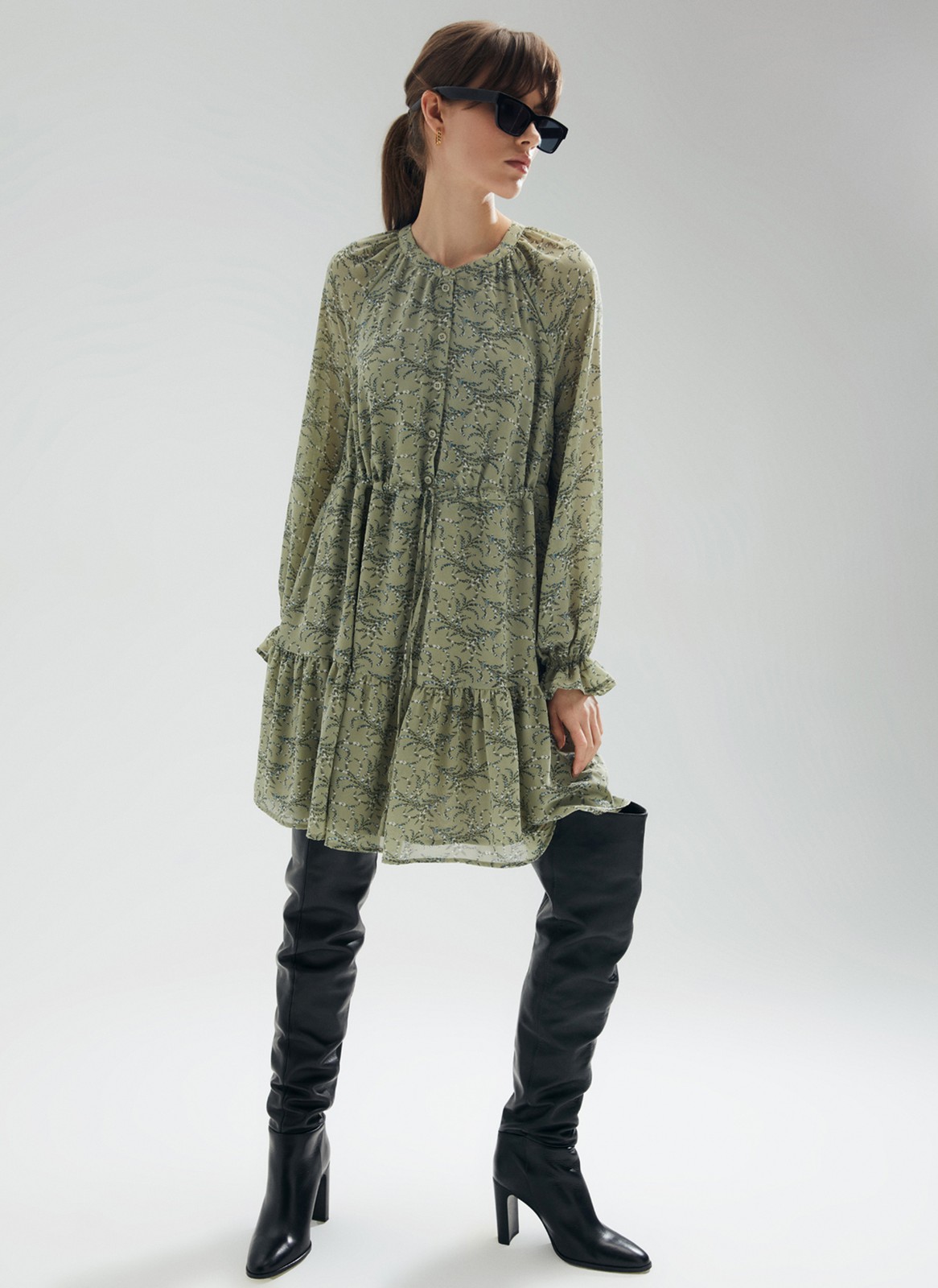 Платье-мини с ярусами, цвет: оливковый Allweneed
Платье-мини из легкого шифона с нежным цветочным принтом. Модель на хлопковой основе, поэтому в ней комфортно и весной, и летом. Свободное платье с ярусами можно затянуть шнурочком из собственной ткани. Воротник лежащая стойка и застежка с пуговицами до линии талии. Воздушные рукава и нижний ярус со сборками. На рукаве есть тонкая резиночка для фиксации. Нам уже не терпится закружиться в платье среди цветов и деревьев.
На модели размер XS\S