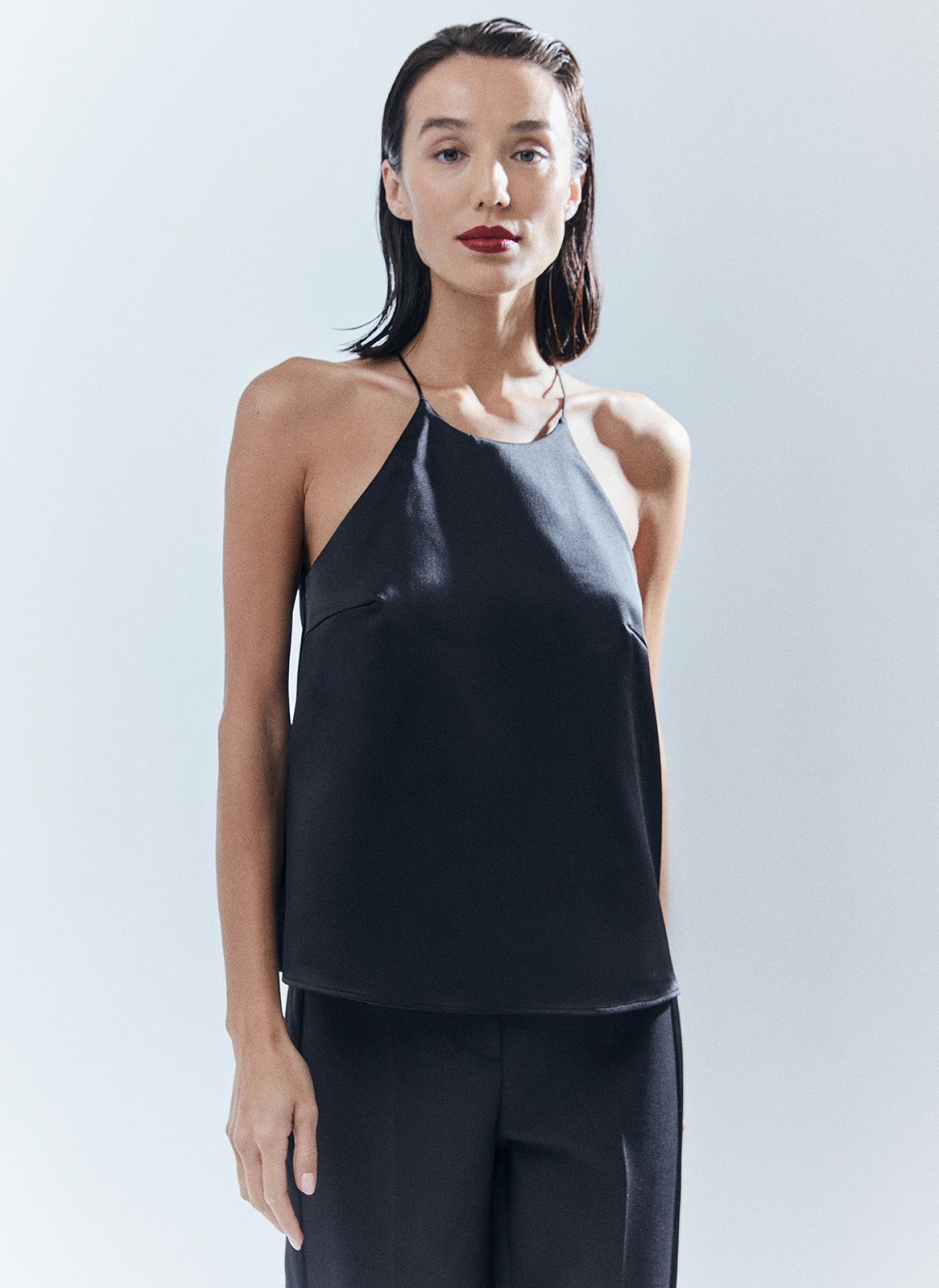 Топ на тонких бретелях в бельевом стиле. Модель выполнена из ткани с деликатным отливом, чтобы сиять под светом праздничных огней. На изделии есть специальные вытачки для лучшей посадки. Мы создали модель с трендовым вырезом халтер. Сочетайте с любимой юбкой или брюками из новогодней капсулы, а также носите после праздников и даже летом топ получился довольно универсальным.

