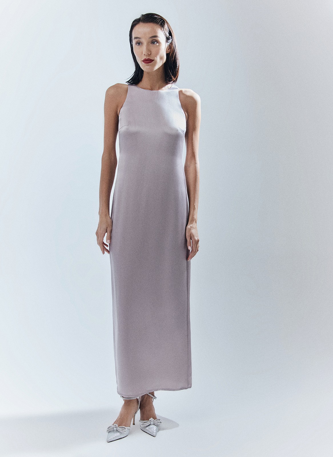 Платье длины макси с вырезом халтер. Легкая и летящая модель переливается и струится нежным водопадом по вашей коже. Специальная вытачка обеспечивает хорошую посадку по фигуре. Модель не слишком свободная, но и не слишком облегает. С помощью пояса-ленточки можно немного затянуть изделие. Наденьте платье на праздничный ужин с сияющими украшениями.

