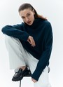 Свитер с высоким горлом, цвет: Индиго Allweneed Шерстянойджемпер oversize. Высокая горловина оформлена ребристой окантовкой для уютного образа и защищает от сильного ветра, а спущенное плечо позволяет носить джемпер с футболками и водолазками для тепла. Модель легко садится под пальто с отложным воротником и заменяет шарф при плохой погоде. Джемпер станет отличным дополнением базового гардероба.