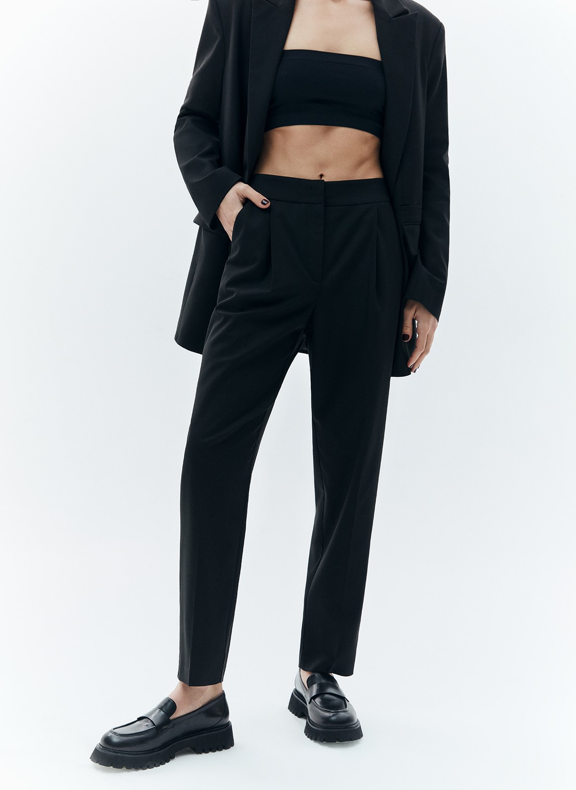 Брюки укороченные, зауженные к низу, цвет: Черный Allweneed Зауженные брюки на средней посадке из костюмной ткани. Модель на складке и со стрелкой. Ткань хорошо держит форму, поэтому изделие долго сохраняет свой первоначальный вид. Два кармана с отрезным бочком и скрытая застёжка на молнию. Мы любим такую длину брюк, которая смотрится оптимально с обувью на каблуке и без него. Идеально, чтобы создать образ деловой леди с жакетом.