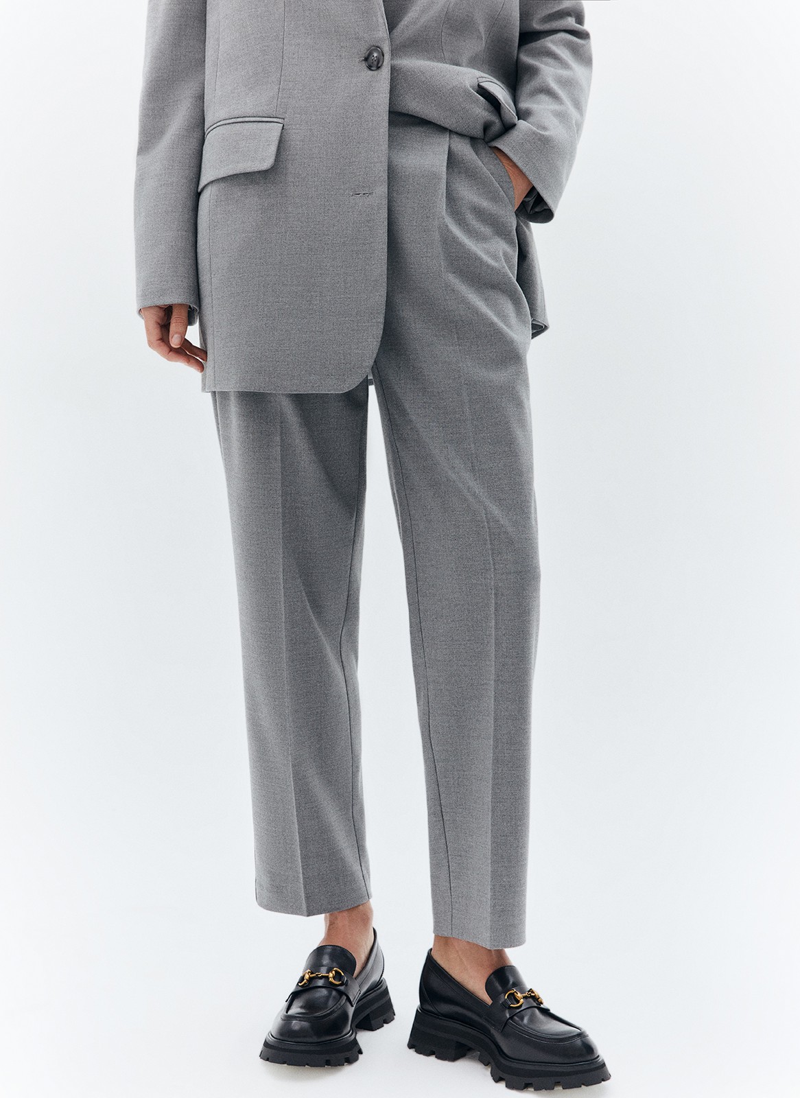 Брюки укороченные, зауженные к низу, цвет: серый Allweneed Зауженные брюки на средней посадке из костюмной ткани. Модель на складке и со стрелкой. Ткань хорошо держит форму, поэтому изделие долго сохраняет свой первоначальный вид. Два кармана с отрезным бочком и скрытая застёжка на молнию. Мы любим такую длину брюк, которая смотрится оптимально с обувью на каблуке и без него. Идеально, чтобы создать образ деловой леди с жакетом.