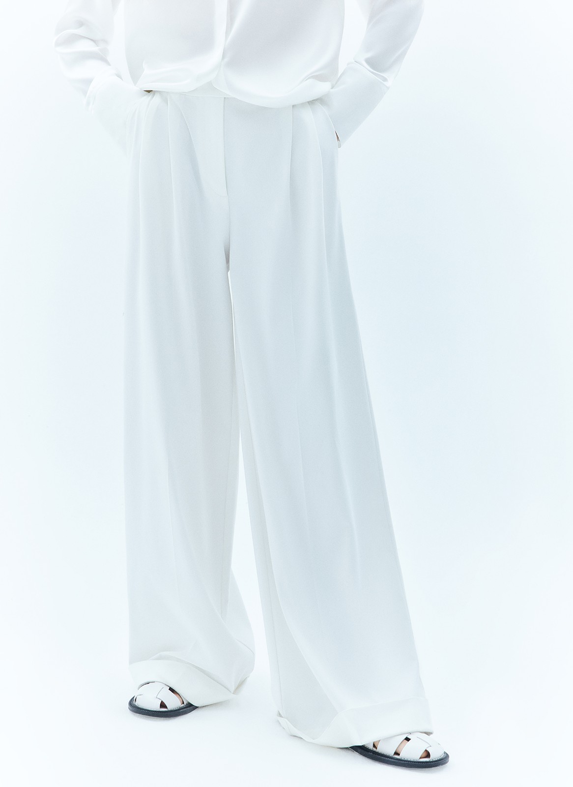 Широкие брюки полной длины с манжетами. Выполнены из мягкой, достаточно тонкой, но формоустойчивой костюмной ткани, благодаря которой будет комфортно весной. Удобная скрытая застёжка на крючки и посадка на уровне талии. Модель удлиняет силуэт. Советуем носить комплектом с жакетом из новой коллекции.
