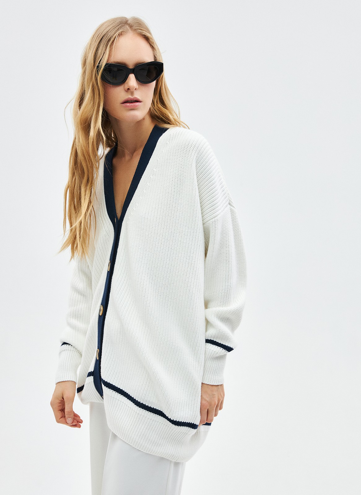 Кардиган фактурный, цвет: Молочно-синий Allweneed Объёмный кардиган крупной вязки. Дарит уют, сохраняя при этом статусность образа благодаря сочетанию оттенков и классическому фасону изделия словно из журналов и фильмов прошлого. V-образный вырез подчёркивает красоту зоны декольте. Длинные рукава с эластичными манжетами и застёжка на крупные роговые пуговицы. По низу изделия пущена контрастная полоска в тон окантовке, что отсылает нас к морской тематике. Прекрасный выбор для вечерних посиделок на веранде.
