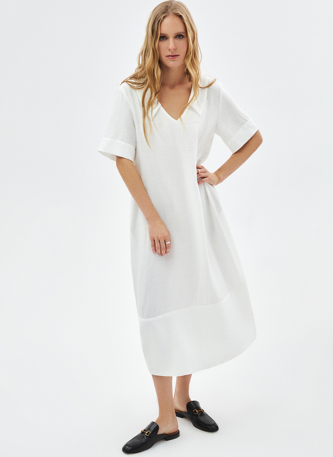 Платье объемное миди с воротником, цвет: молочный Allweneed Объёмное платье длины миди. Модель с отложным воротником и короткими широкими рукавами. V-образный вырез подчёркивает красоту зоны декольте и ключиц. На платье внизу есть отрезная деталь, которая помогает сохранить объём юбки. Мы добавили к платью дополнительно пояс, чтобы можно было сделать акцент на талии. Приятная к телу фактура. Сочетайте модель с любимым ботинками, туфлями или с босоножками в жаркое время.