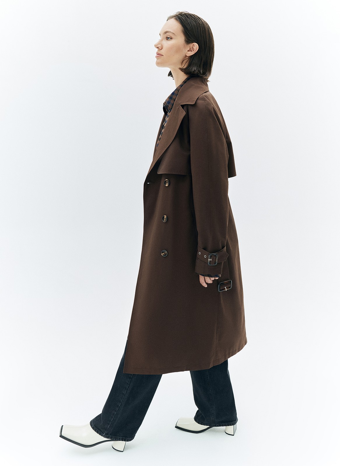 Тренч, цвет: коричневый Allweneed Плащ двубортного кроя с застёжкой на крупные контрастные пуговицы. Мы сохранили все детали классической модели: отлетную кокетку, А-силуэт, манжеты для фиксации рукава и длинный пояс на талии. Мы любим плащ за то, что с ним можно составлять женственные и универсальные повседневные образы.