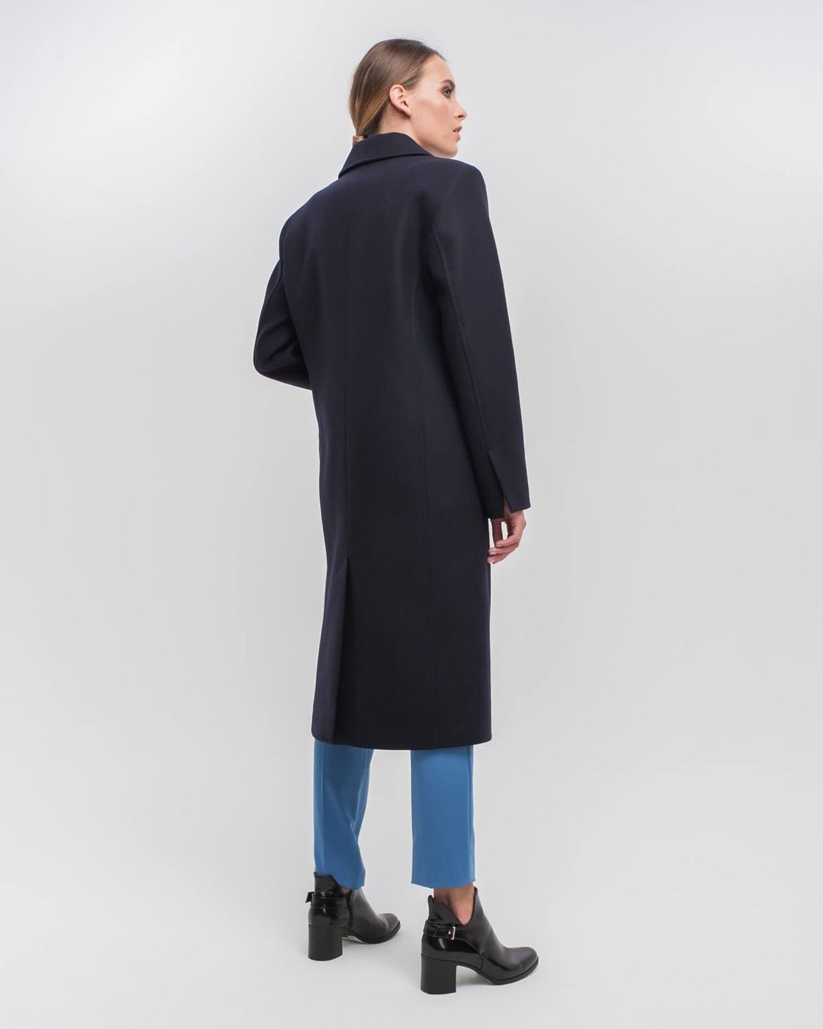 Однобортное пальто приталенного силуэта с клапанами на карманах и потайной застежкой на пуговицы. Линия отстрочек на лацканах и четкие линии плеч формируют современный силуэт.