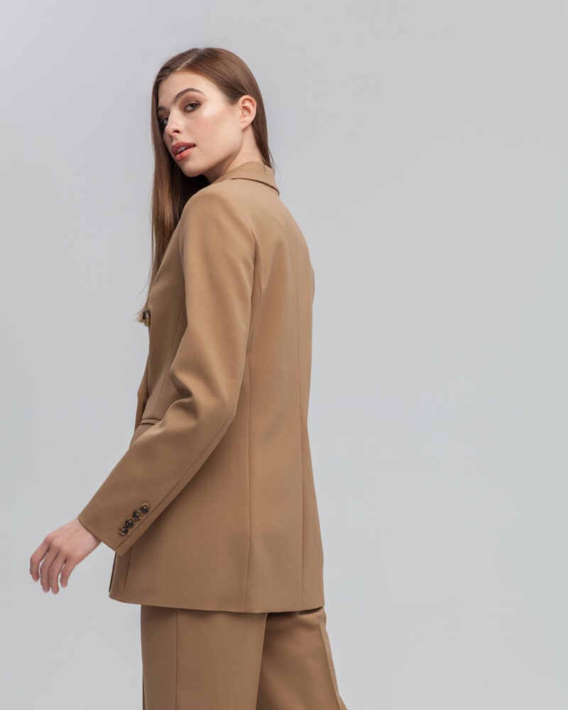 Слегкаприталенный двубортный жакет послужит удачным дополнением не только к деловым нарядам, но и к повседневным образам.Незаменимый элемент базового гардероба, который легко сочетать с брюками, юбками, платьями и денимом.