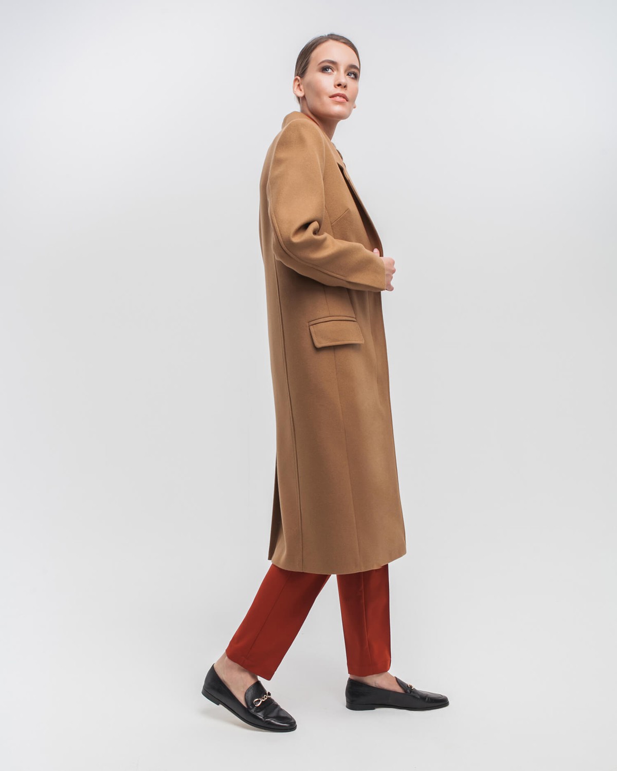 Однобортное пальто приталенного силуэта с клапанами на карманах и потайной застежкой на пуговицы. Линия отстрочек на лацканах и четкие линии плеч формируют современный силуэт.
