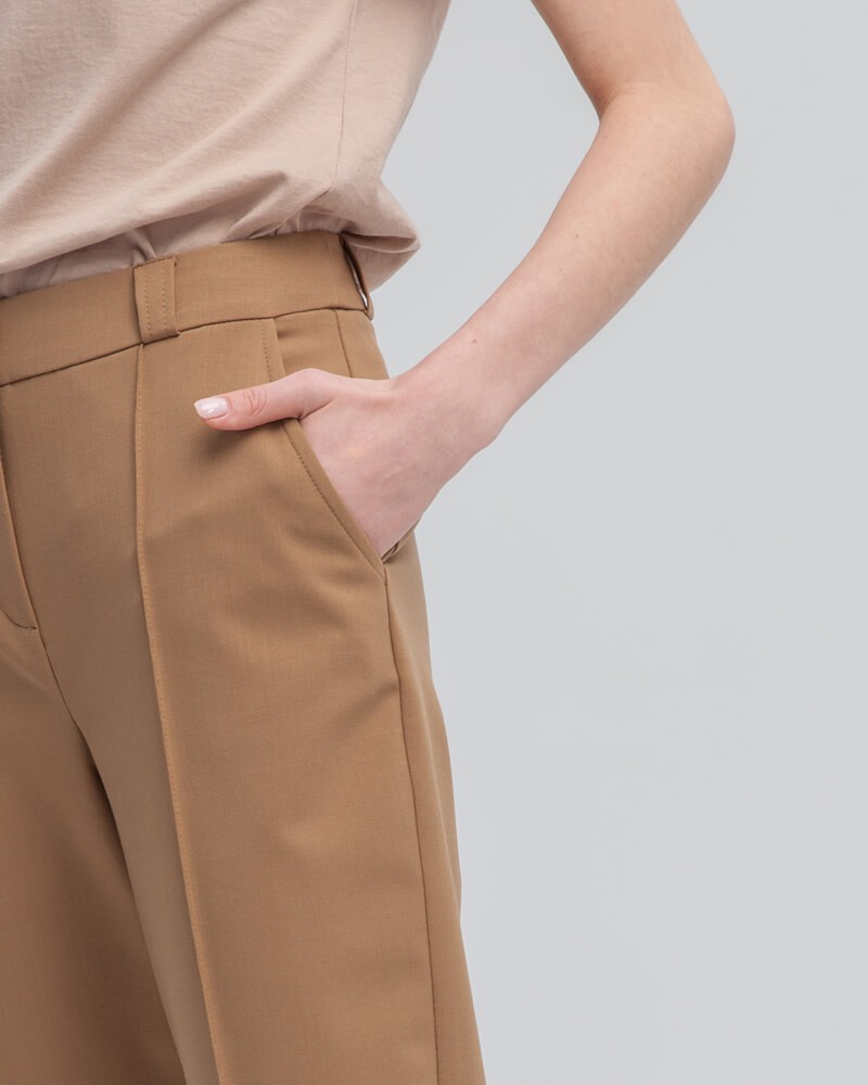 Зауженные к низу брюки полуприлегающего силуэта со средней посадкой и застежкой на молнию и крючки. Посадка на талии и стрелка визуально удлиняют ноги и делают ваш образ более собранным и элегантным.